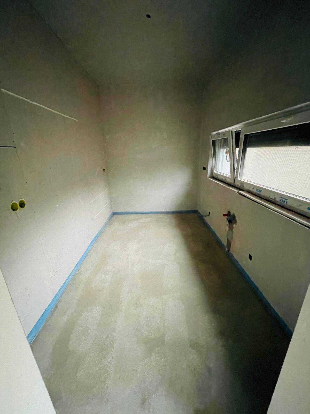 Kleiner Rohbau-Raum mit Estrichboden und Fenster, ideal als Abstellraum oder Gäste-WC.