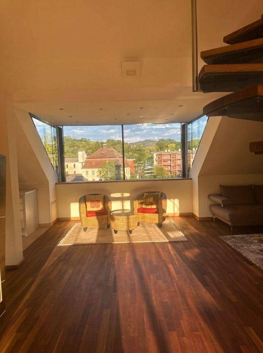 Gemütliches Wohnzimmer mit Holzboden, Panoramablick und einer eleganten Wendeltreppe.