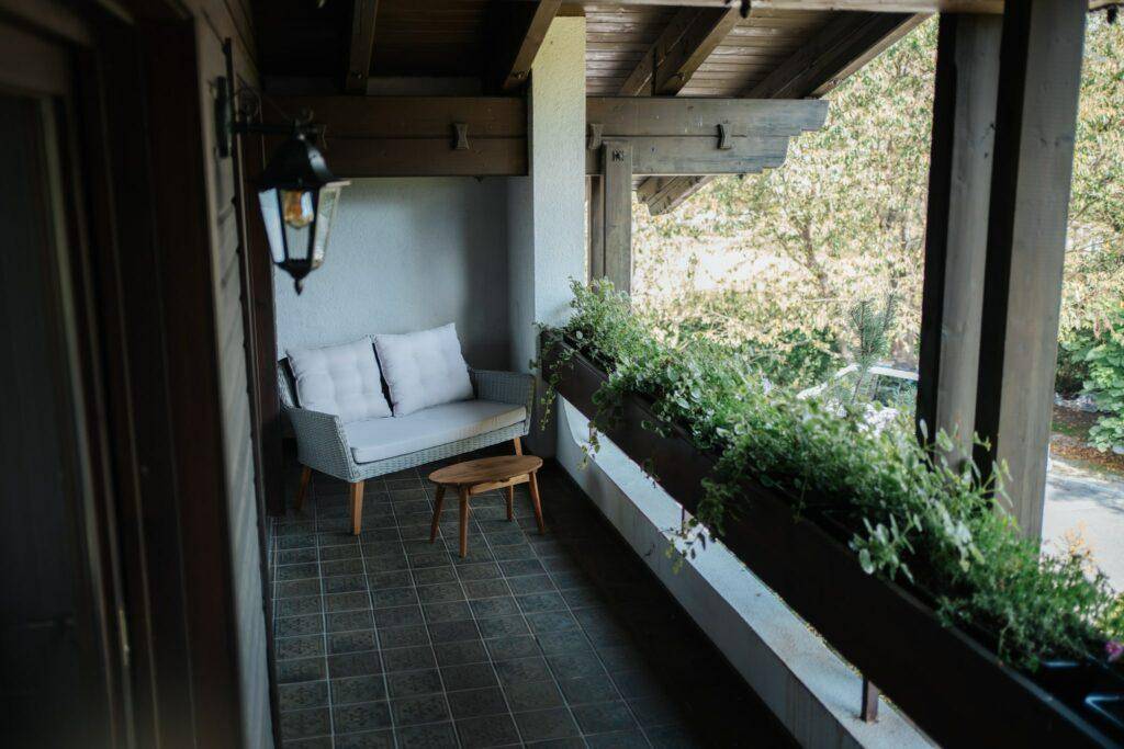Gemütlicher Balkon mit bequemer Sitzgelegenheit und Pflanzenkästen, perfekt für ruhige Stunden.