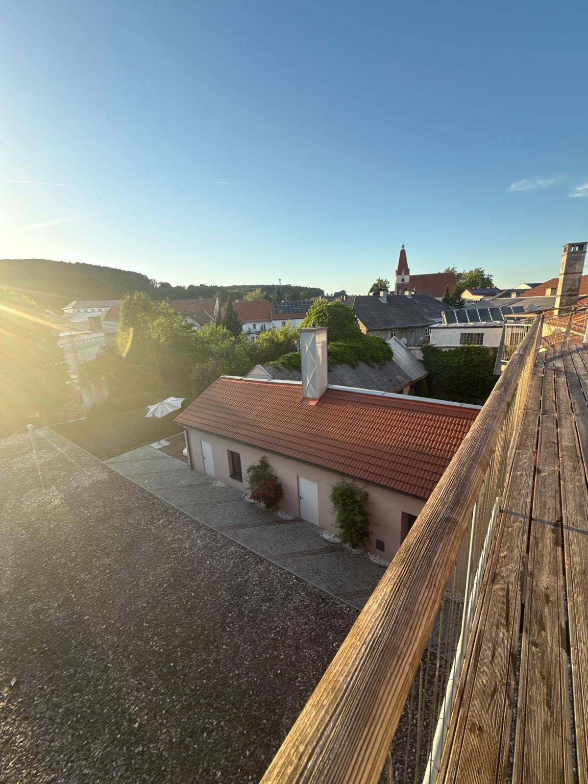 Panoramablick von einer Dachterrasse über die Dächer einer charmanten Stadt bei Sonnenuntergang.