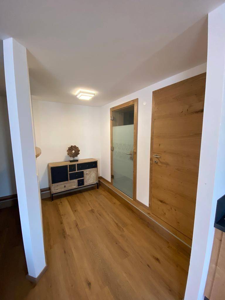 Heller Flur mit Holzboden und modernen Holztüren, die zu verschiedenen Räumen führen.