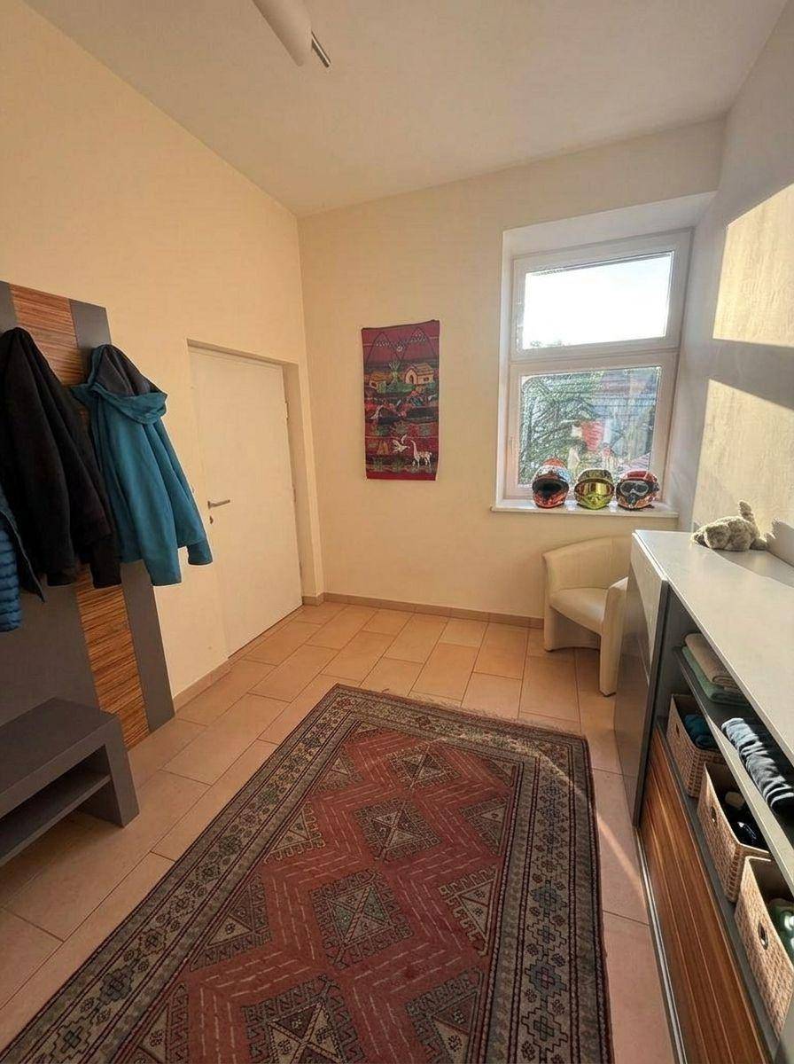 Freundlicher Flur mit Fliesenboden, Fenster und praktischer Garderobe, die viel Stauraum bietet.