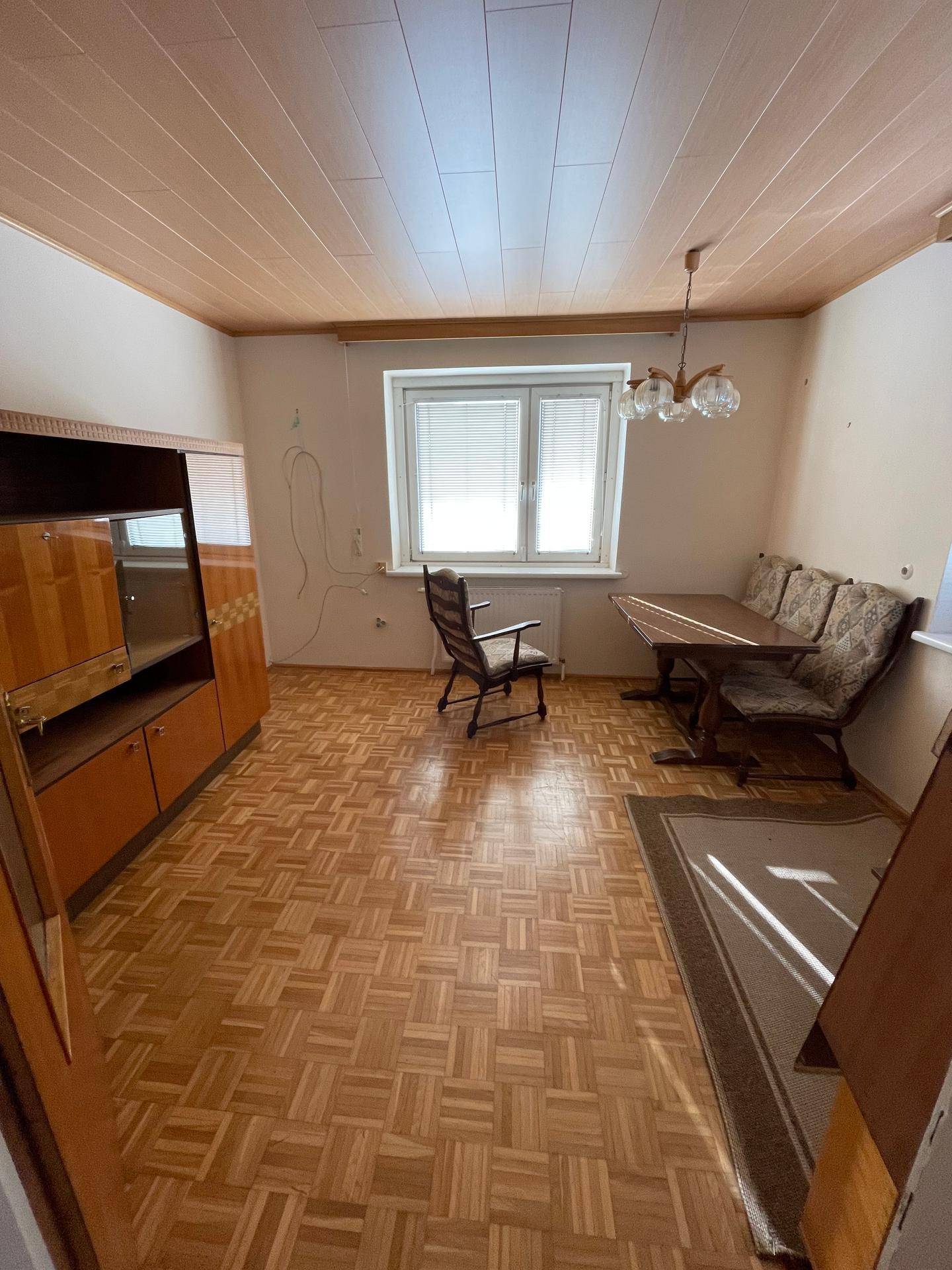 Esszimmer mit Parkettboden, Holzdecke und traditionellen Möbeln.