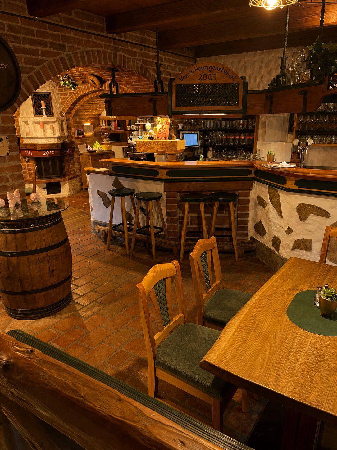 Rustikale Bar mit Holzelementen, Ziegelwänden und traditionellen Hockern, einladende Atmosphäre.