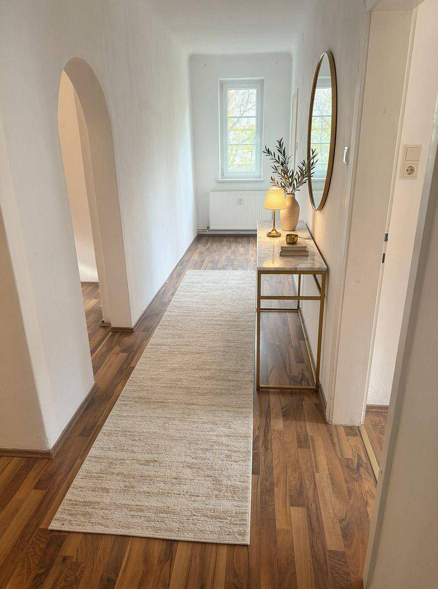 Heller Flur mit Holzboden, elegantem Konsolentisch und dekorativem Spiegel.