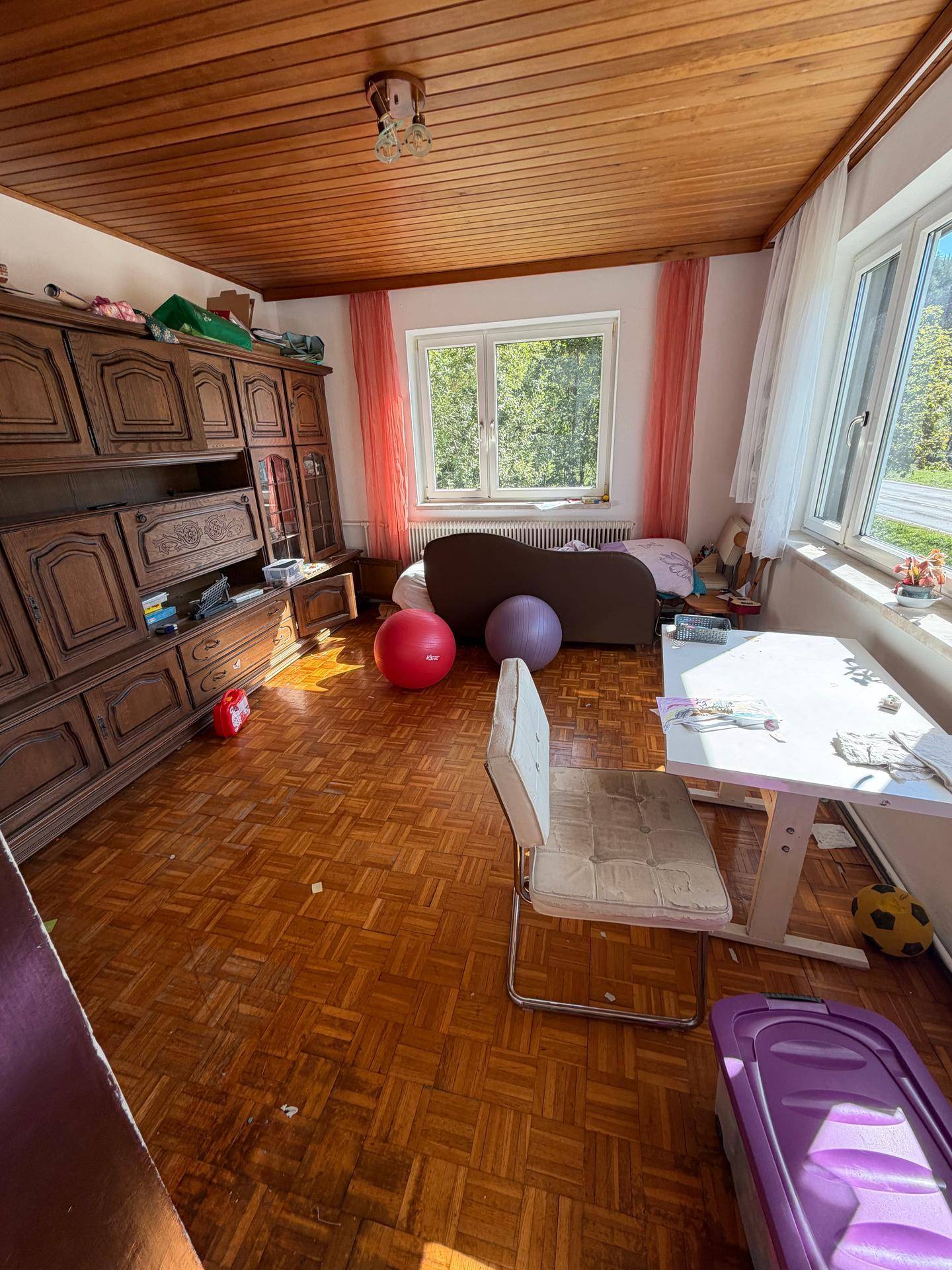 Schlafzimmer mit Holzbalkendecke, Parkettboden und traditionellen Möbeln.