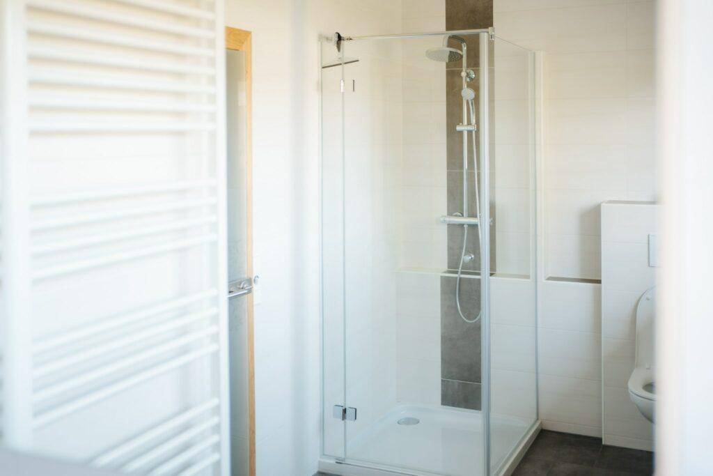 Helles Badezimmer mit moderner Glasdusche und Wand-WC, in sauberem und gepflegtem Zustand.