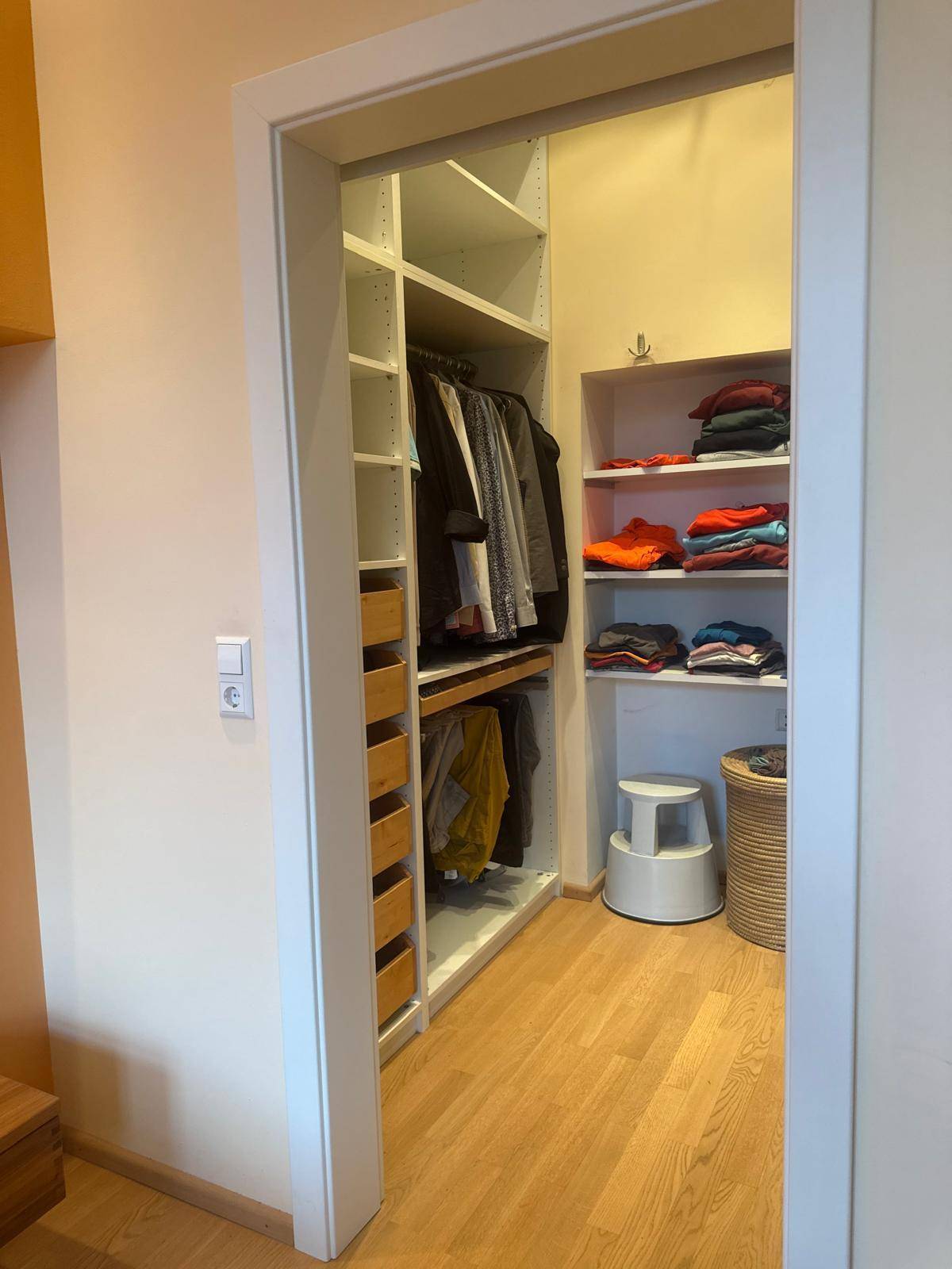 Gut organisierter begehbarer Kleiderschrank mit Regalen und Schubladen für optimale Aufbewahrung.