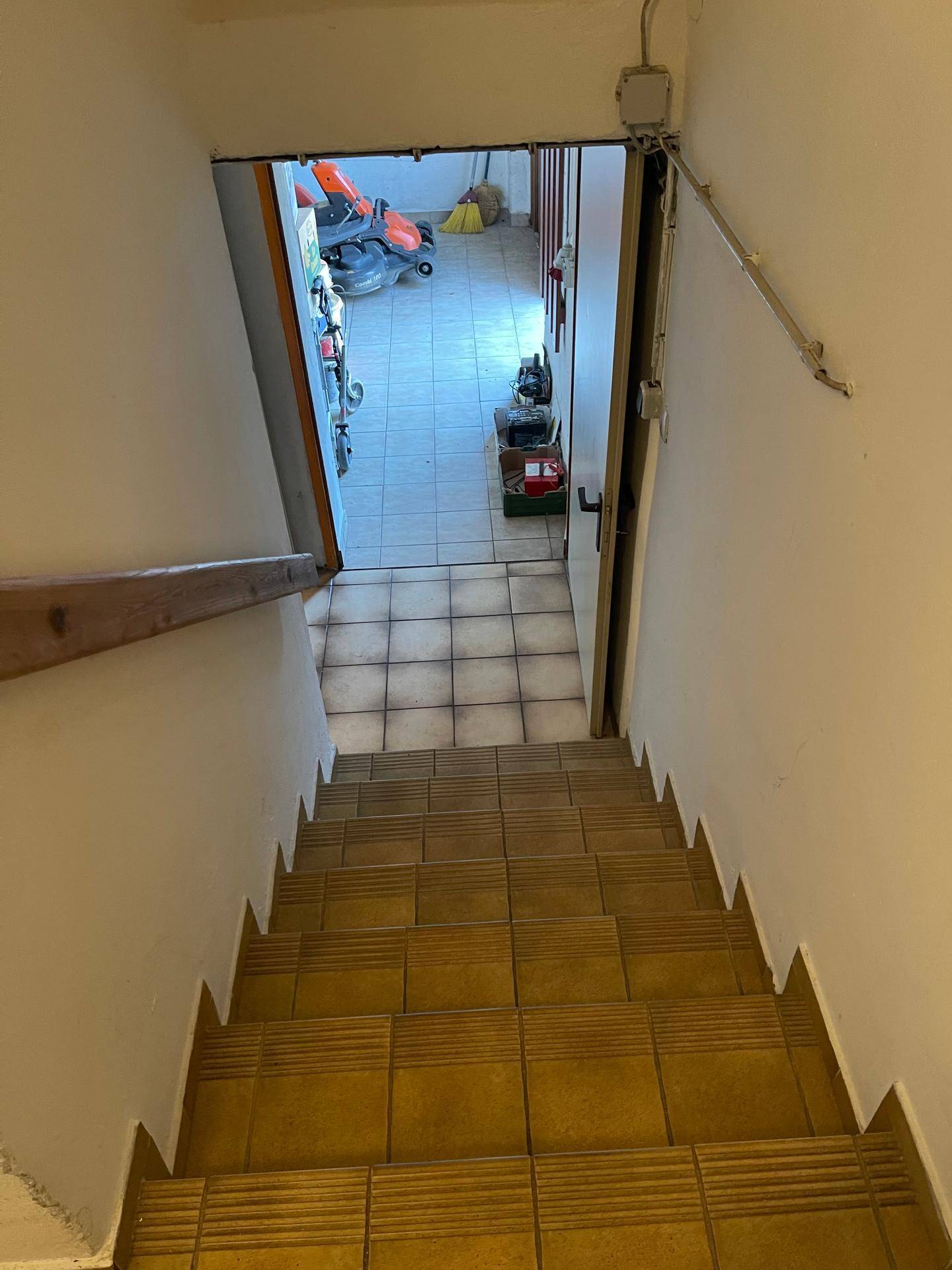 Treppe zum Keller mit Fliesenboden und Blick in den Lagerbereich.