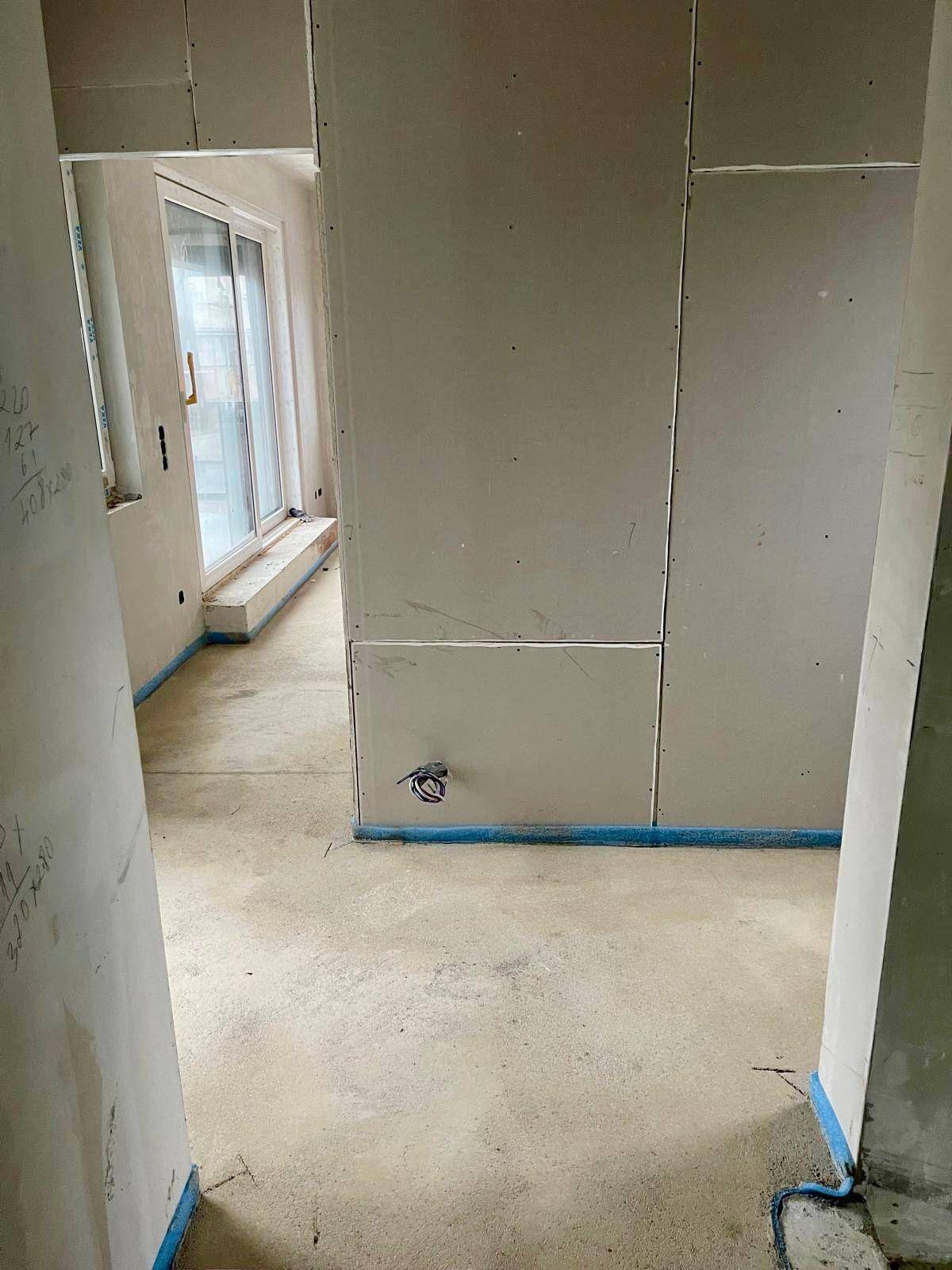 Rohbau-Zimmer mit Estrichboden und Trockenbauwand, bereit für die weitere Gestaltung.