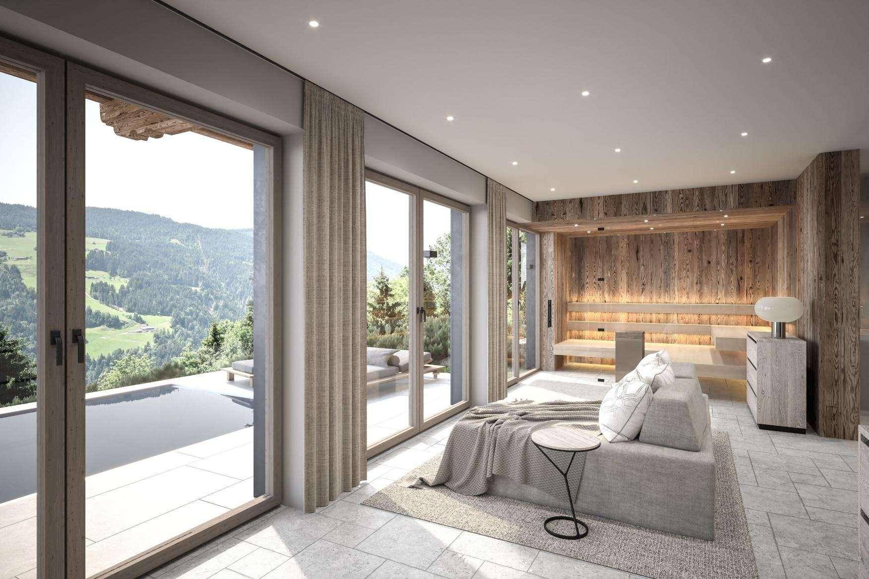 Entspannungsbereich mit Sauna, Tagesbett und großen Fenstern mit Blick auf den Pool und die Berge.