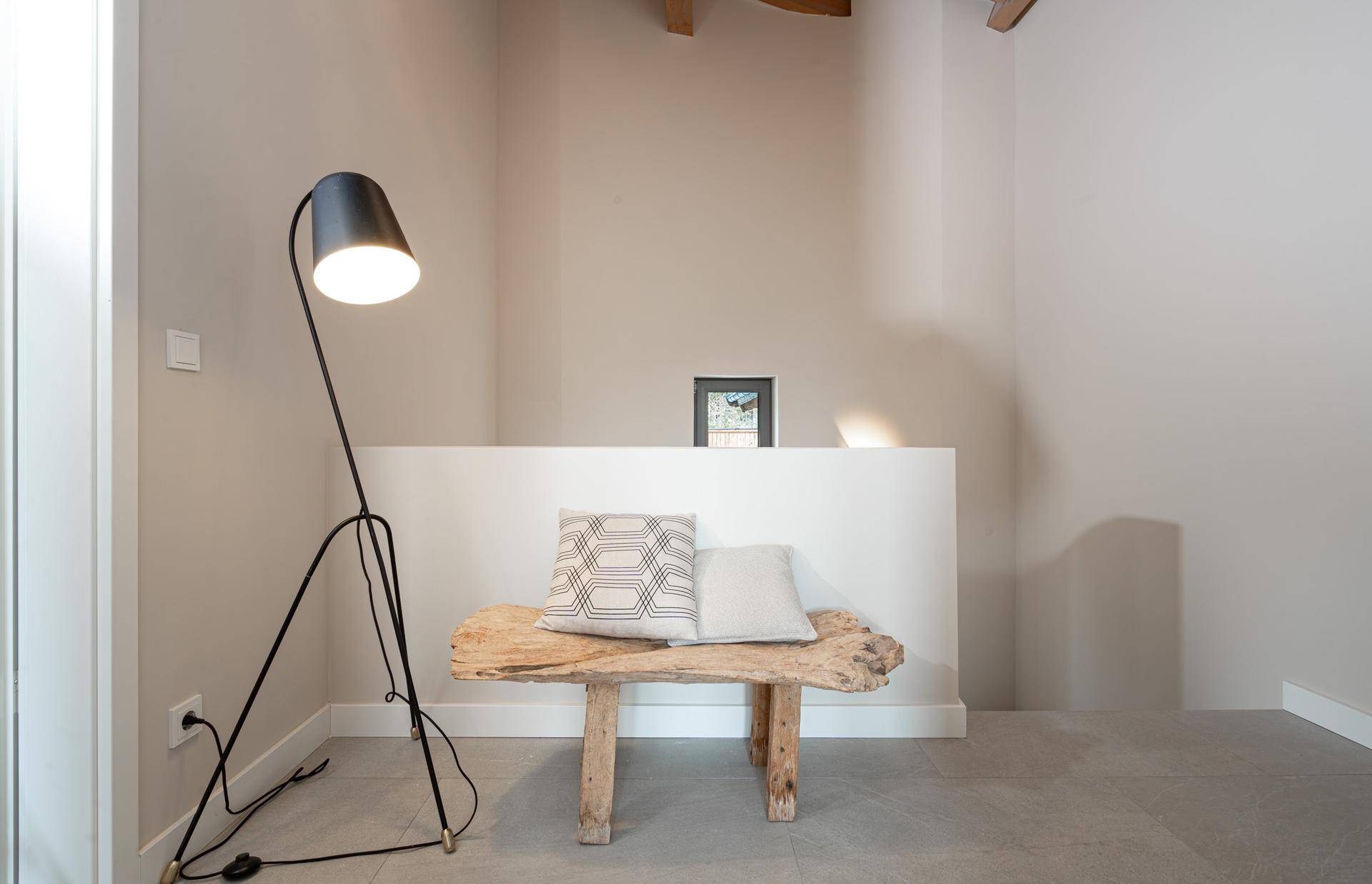 Heller Flurbereich mit Holzsitzbank und Stehlampe, minimalistisch und modern gestaltet.