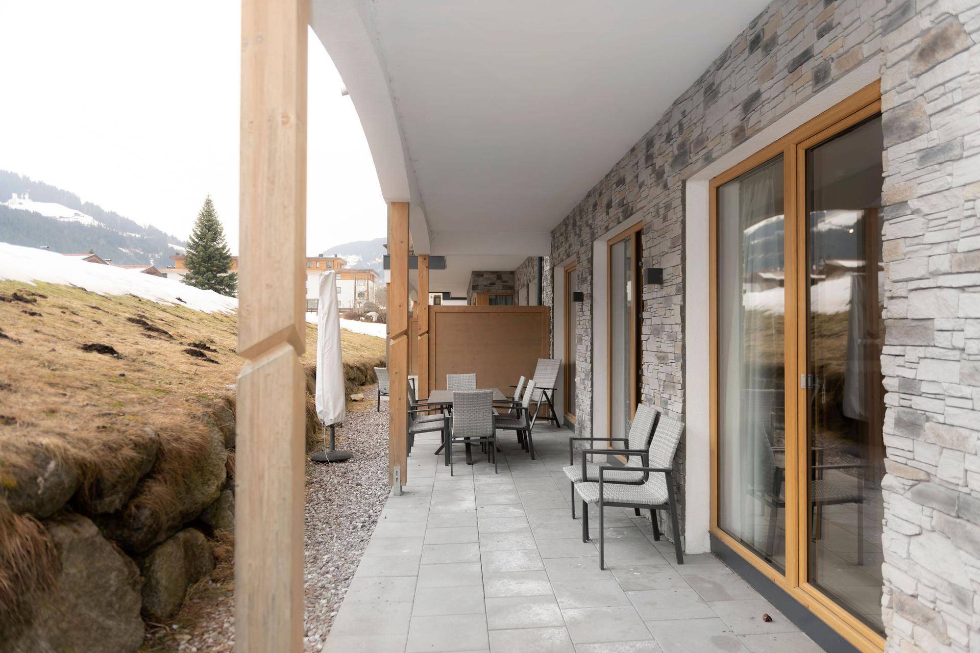 Großzügige Terrasse mit Sitzgelegenheiten und Blick auf die verschneite Berglandschaft.