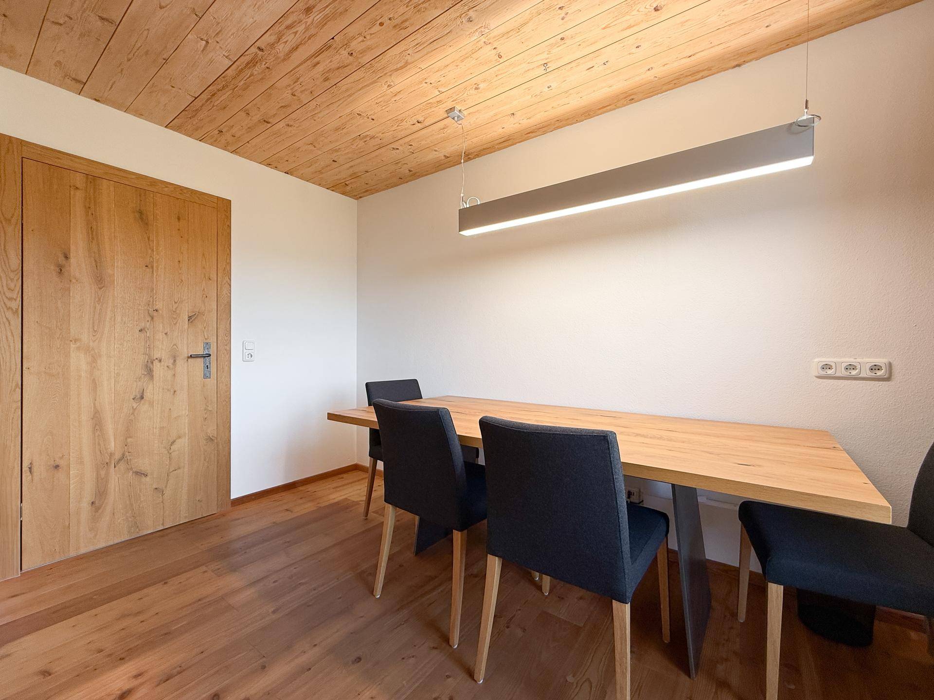 Heller Essbereich mit Holztisch, modernen Stühlen und Holzboden.