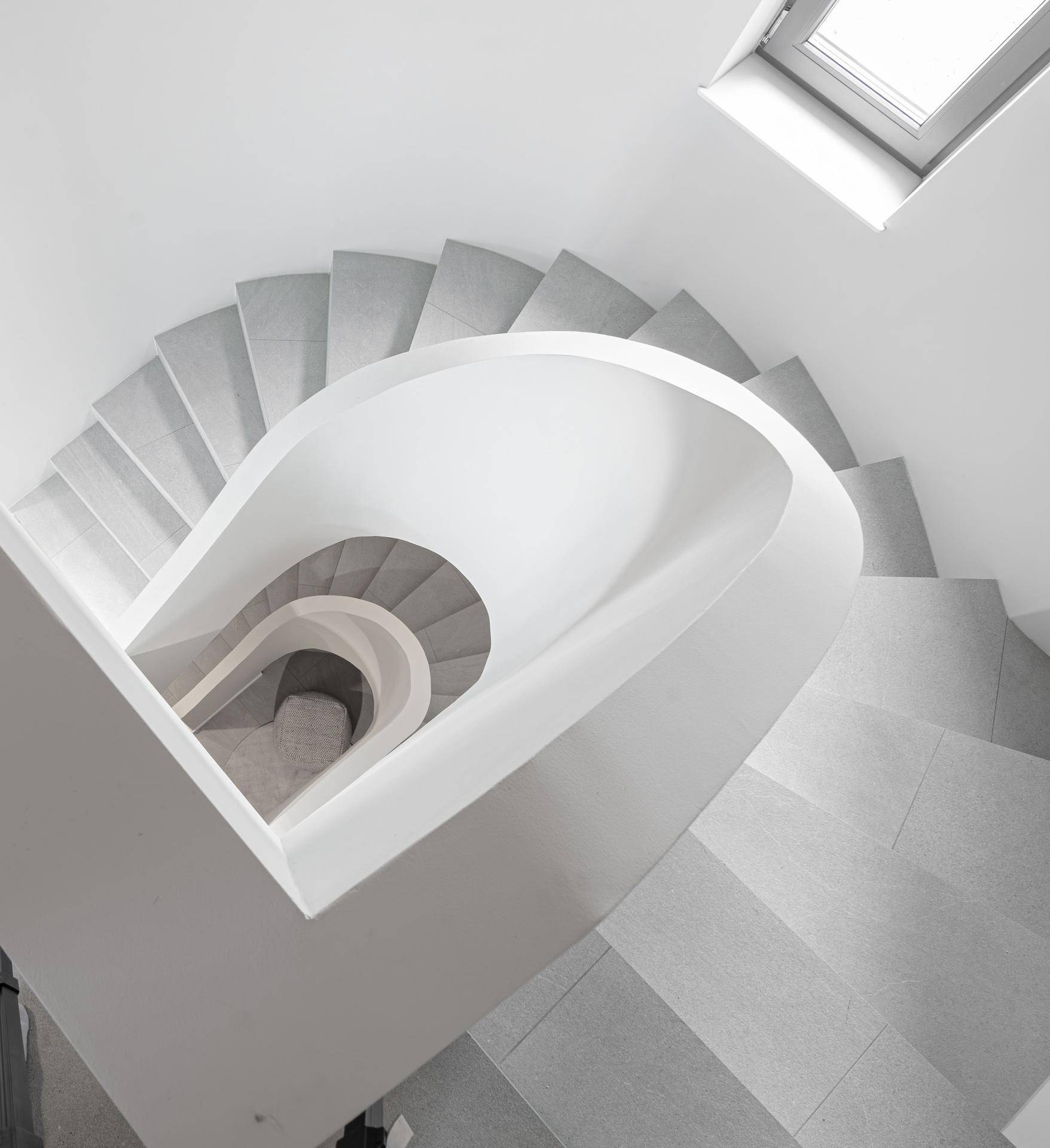 Elegante Wendeltreppe mit Oberlicht, die verschiedene Ebenen des Hauses verbindet.