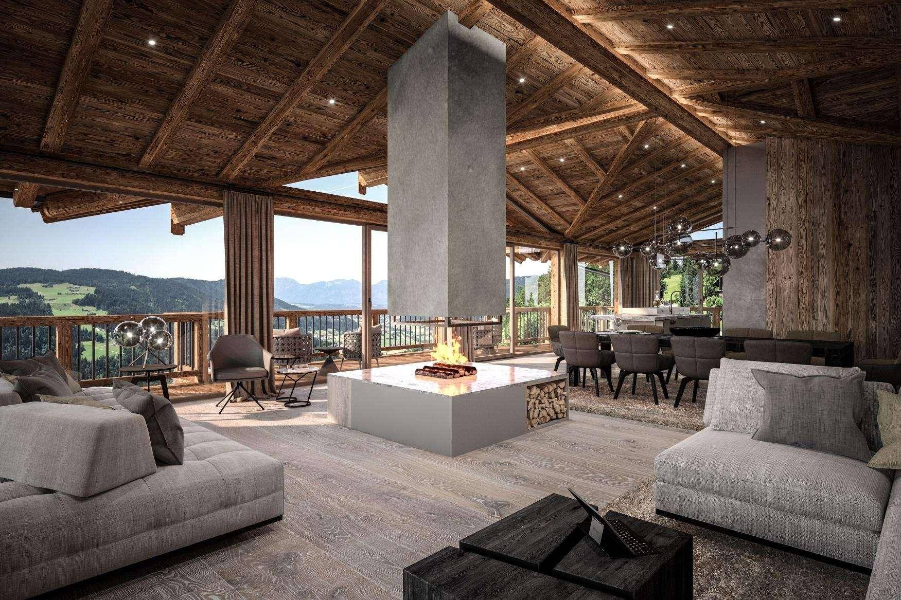 Gemütliches Wohnzimmer mit zentralem Kamin, bequemen Sofas und Panoramablick auf die Berge.