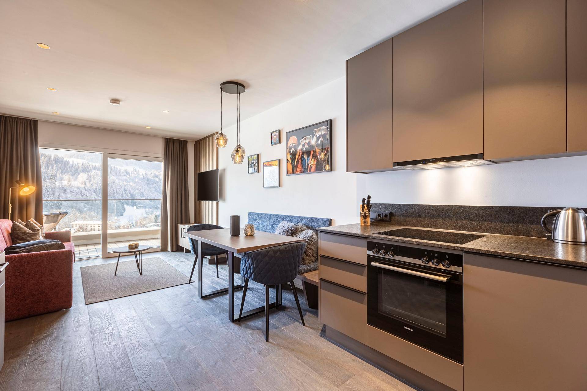 Offener Wohn-Essbereich mit integrierter Küche, Esstisch und Zugang zum Balkon.