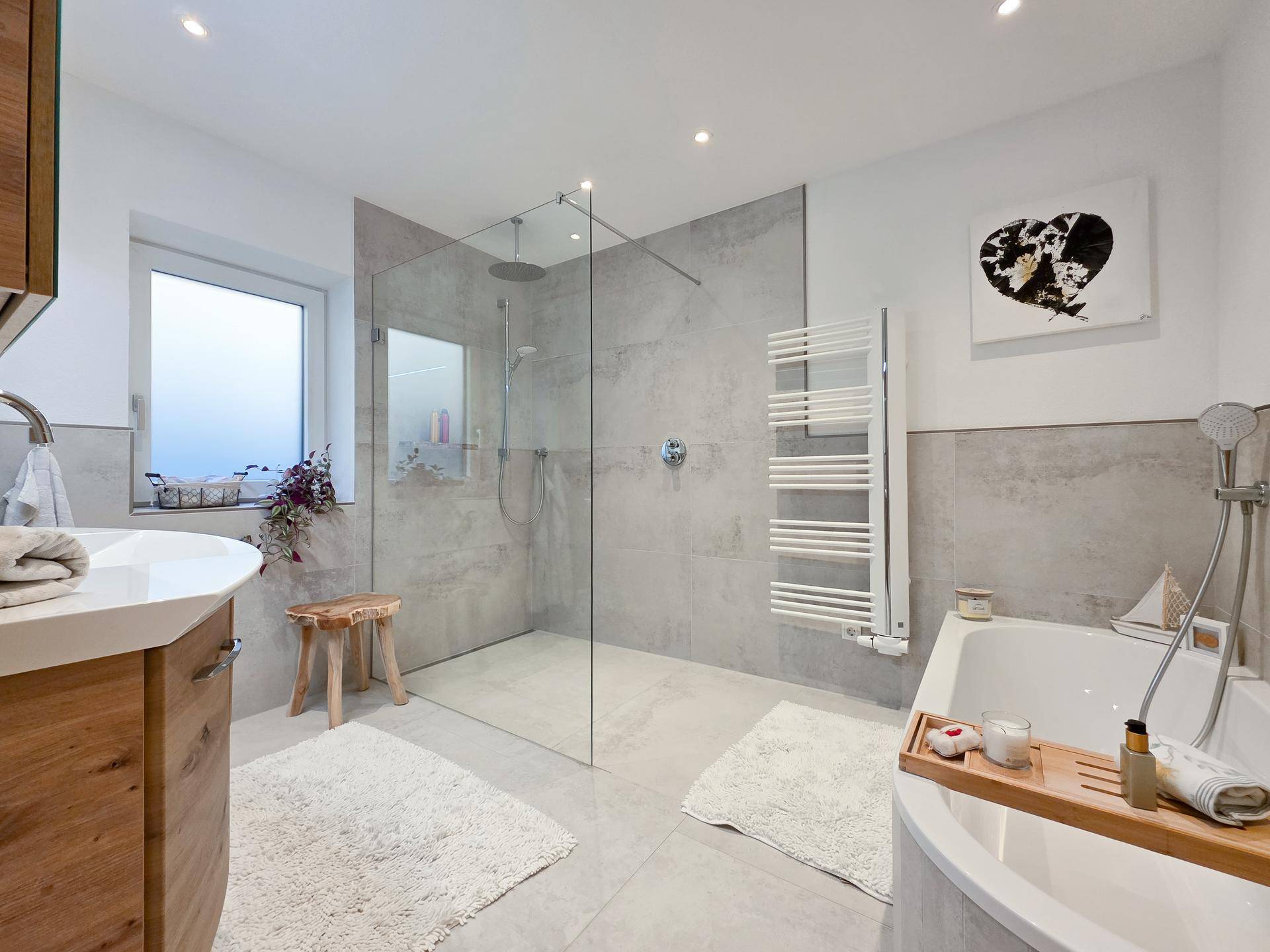Modernes Badezimmer mit begehbarer Dusche, Badewanne und beheiztem Handtuchhalter.