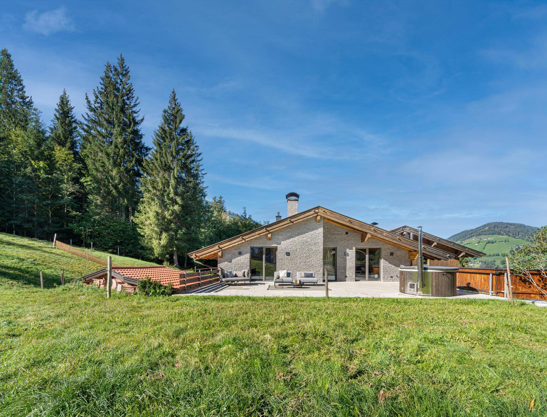 Moderne Villa in alpiner Landschaft mit großzügiger Terrasse und Whirlpool.