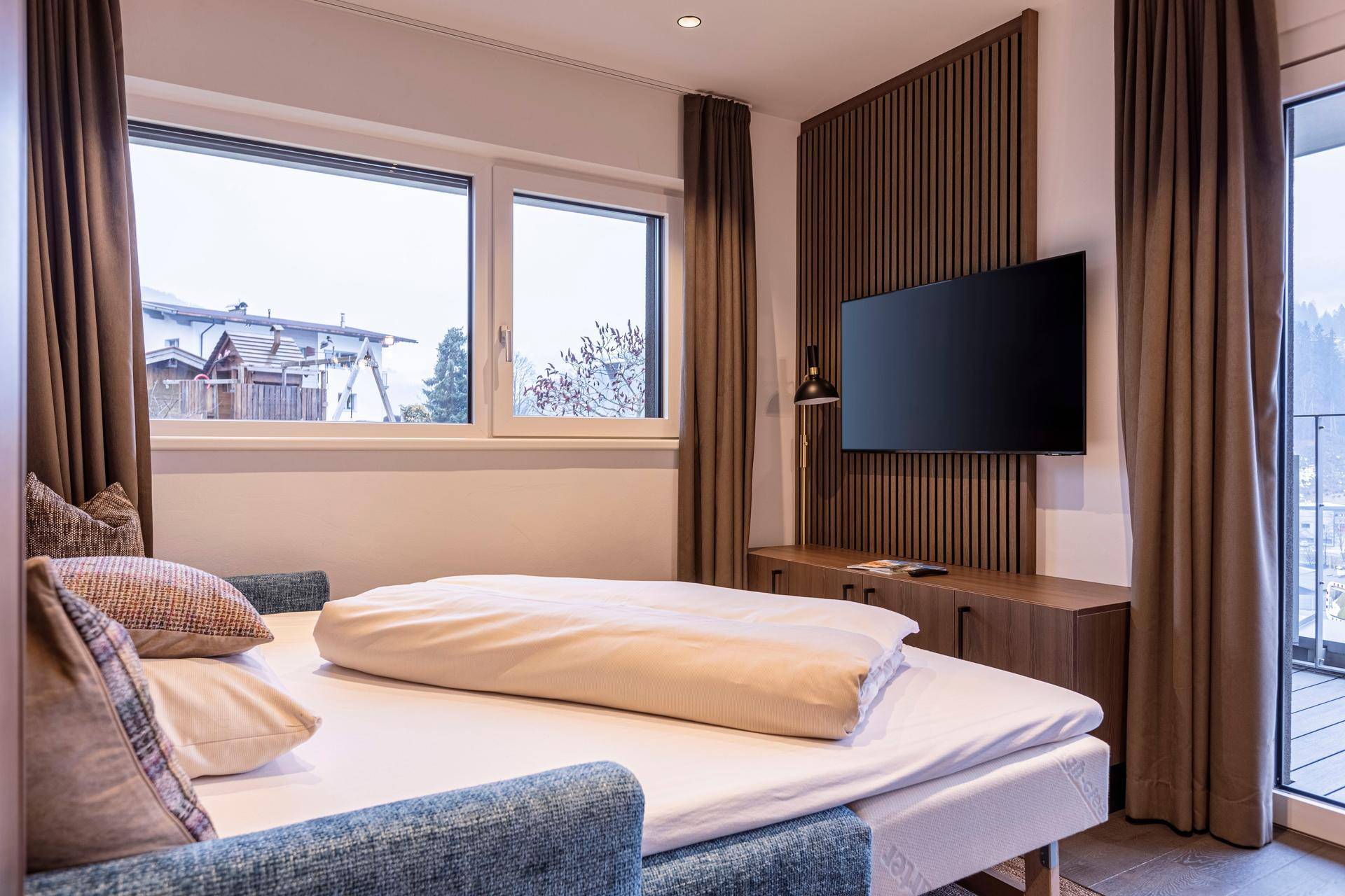 Schlafzimmer mit Einzelbetten, Fernseher und Fenster mit Blick auf die Umgebung.