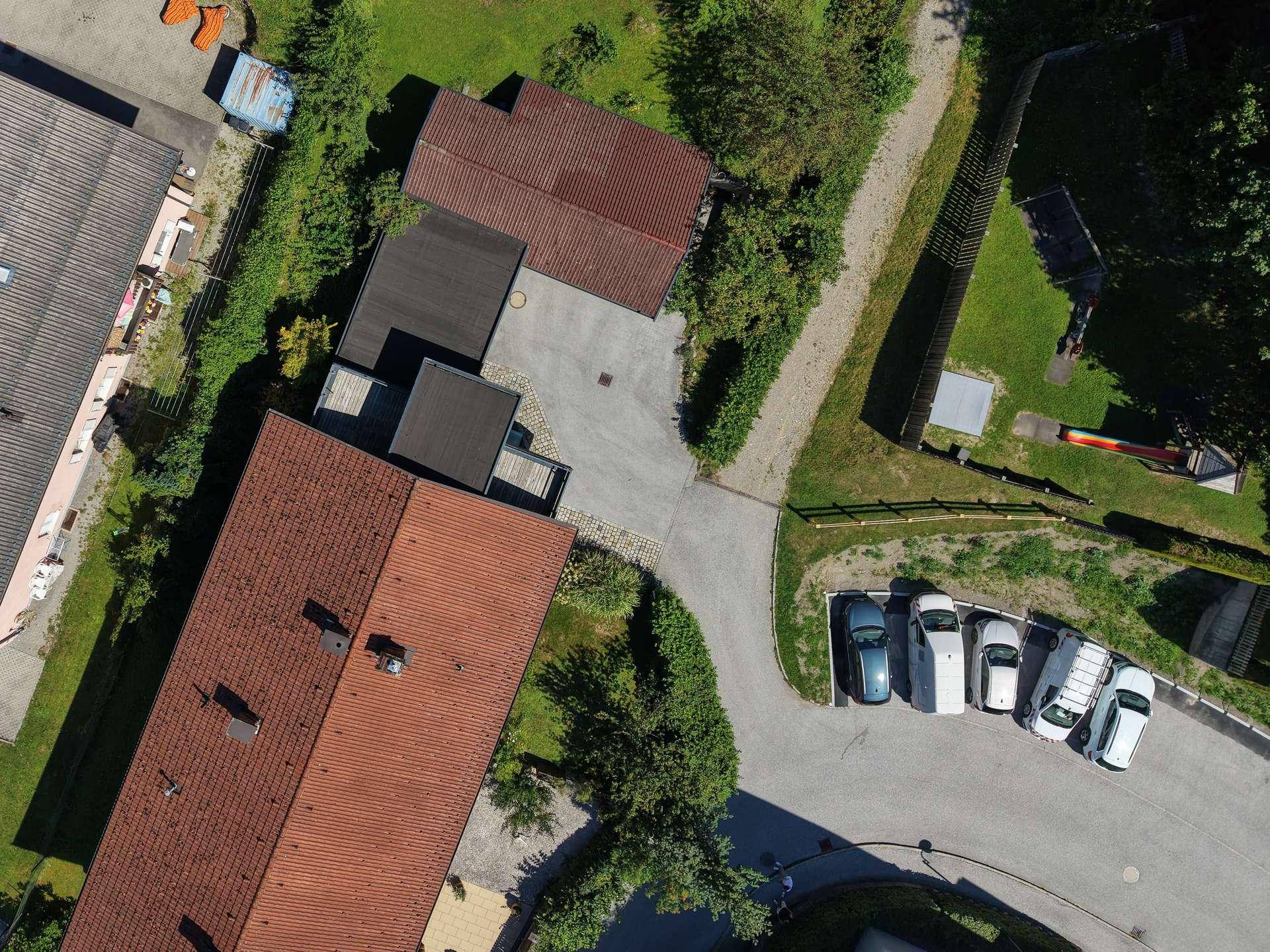 Luftaufnahme des Anwesens mit Gebäuden, Parkplätzen und Grünflächen.