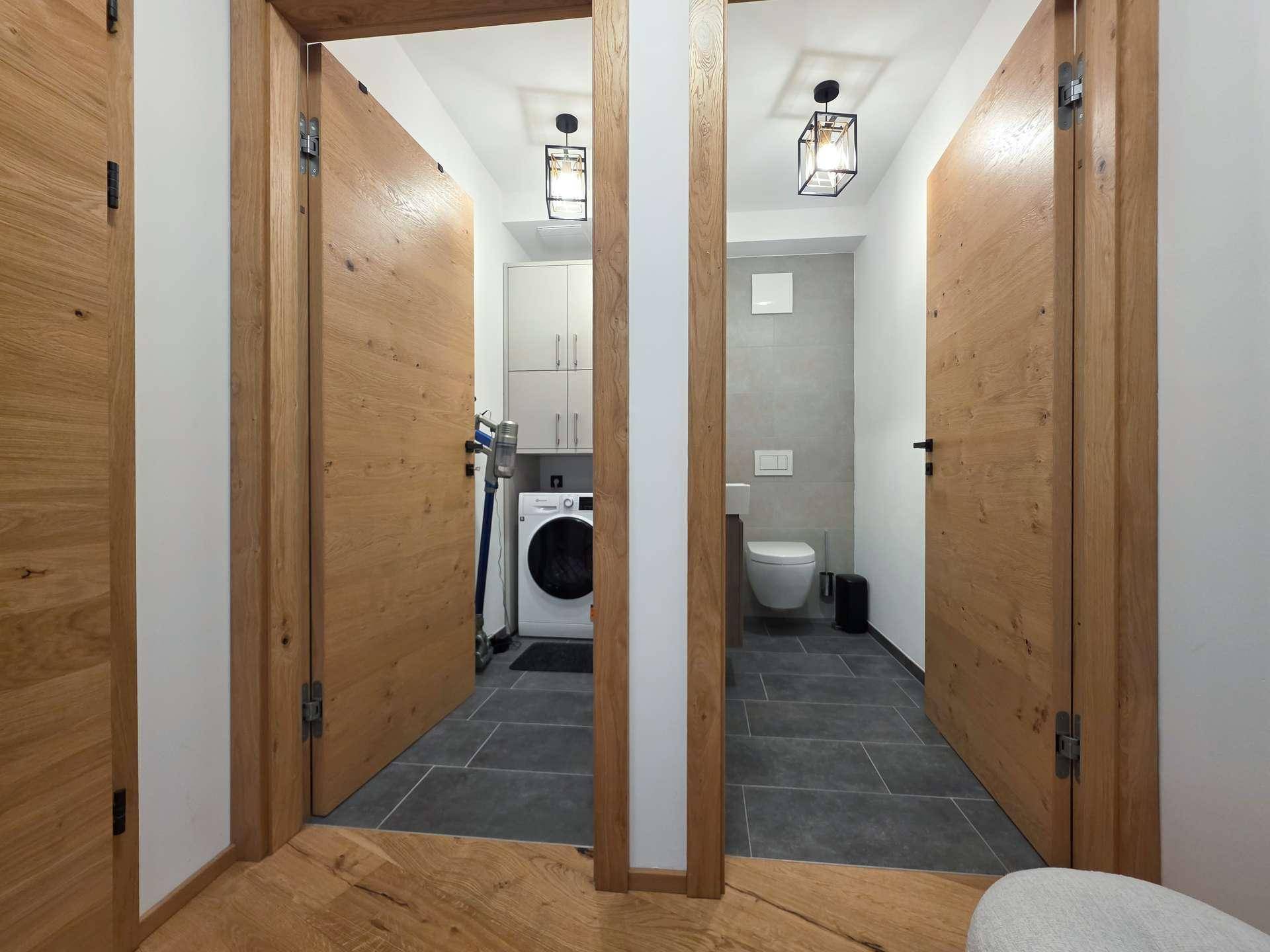 Flur mit Zugang zu einem Hauswirtschaftsraum und einer separaten Toilette.