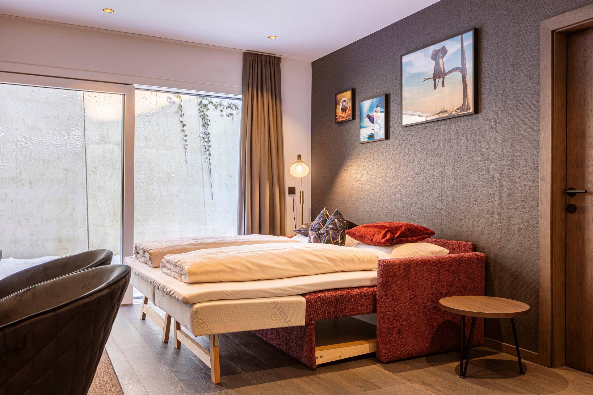 Schlafzimmer mit ausziehbarem Bett und Zugang zu einem kleinen Außenbereich.