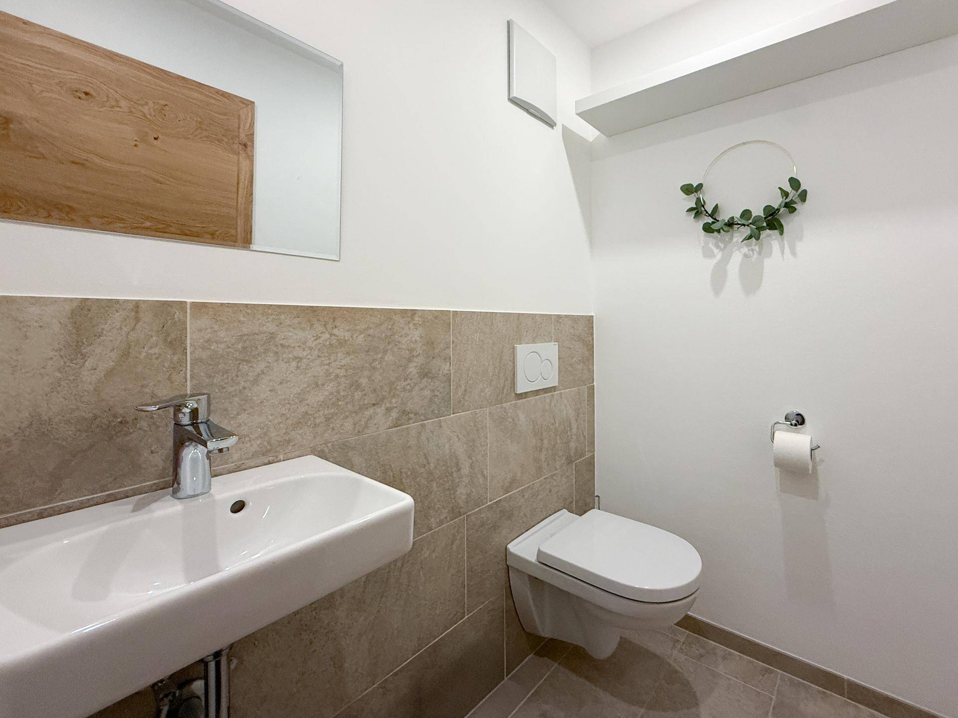 Gäste-WC mit wandhängender Toilette und kleinem Waschbecken.