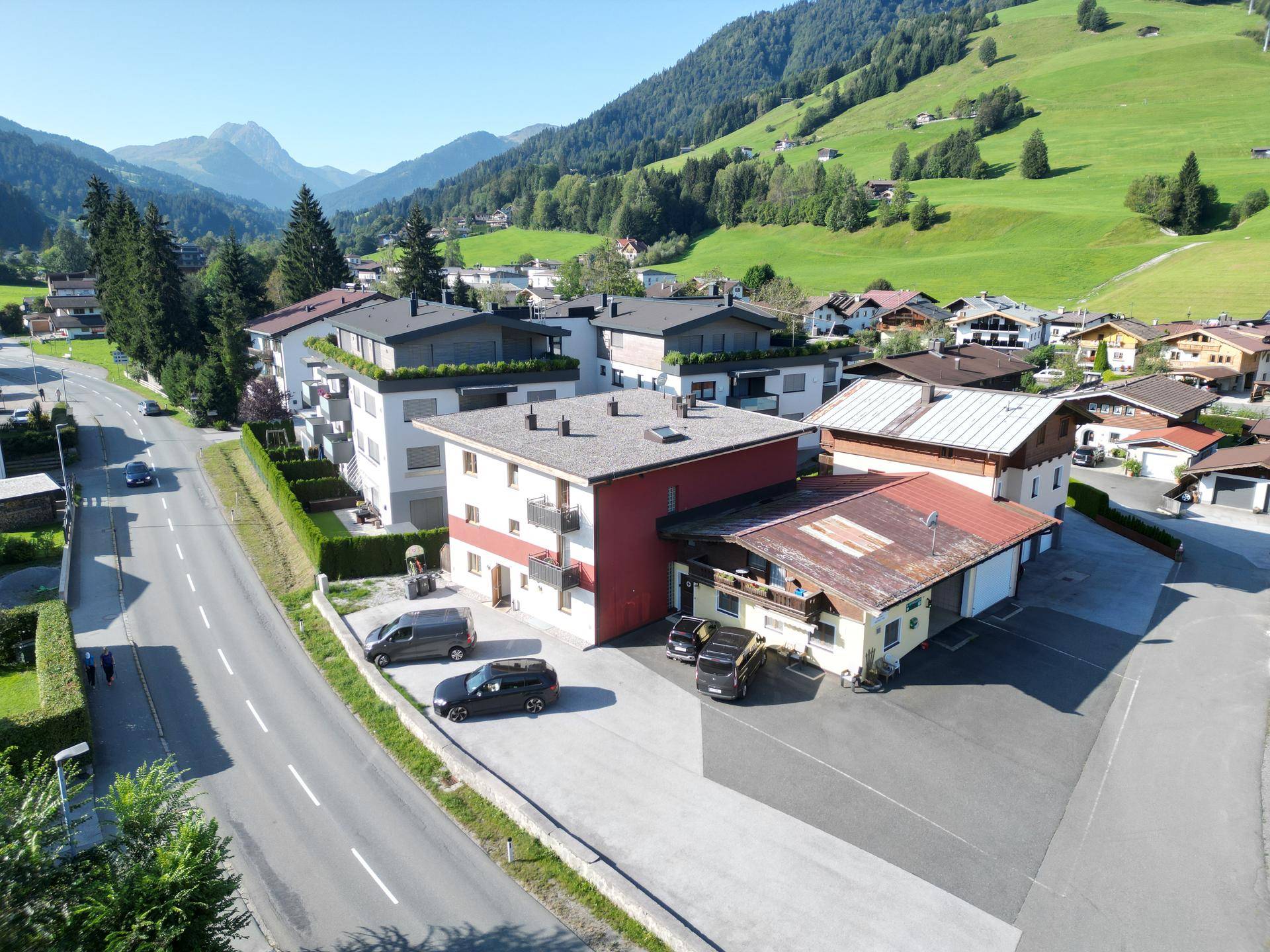 Weitläufige Luftaufnahme des Gebäudekomplexes mit umliegender Landschaft und Bergen.