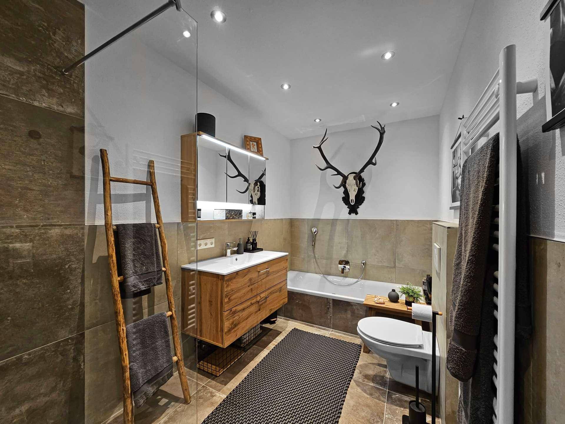 Modernes Badezimmer mit Badewanne, begehbarer Dusche, Einzelwaschbecken und beheiztem Handtuchhalter.