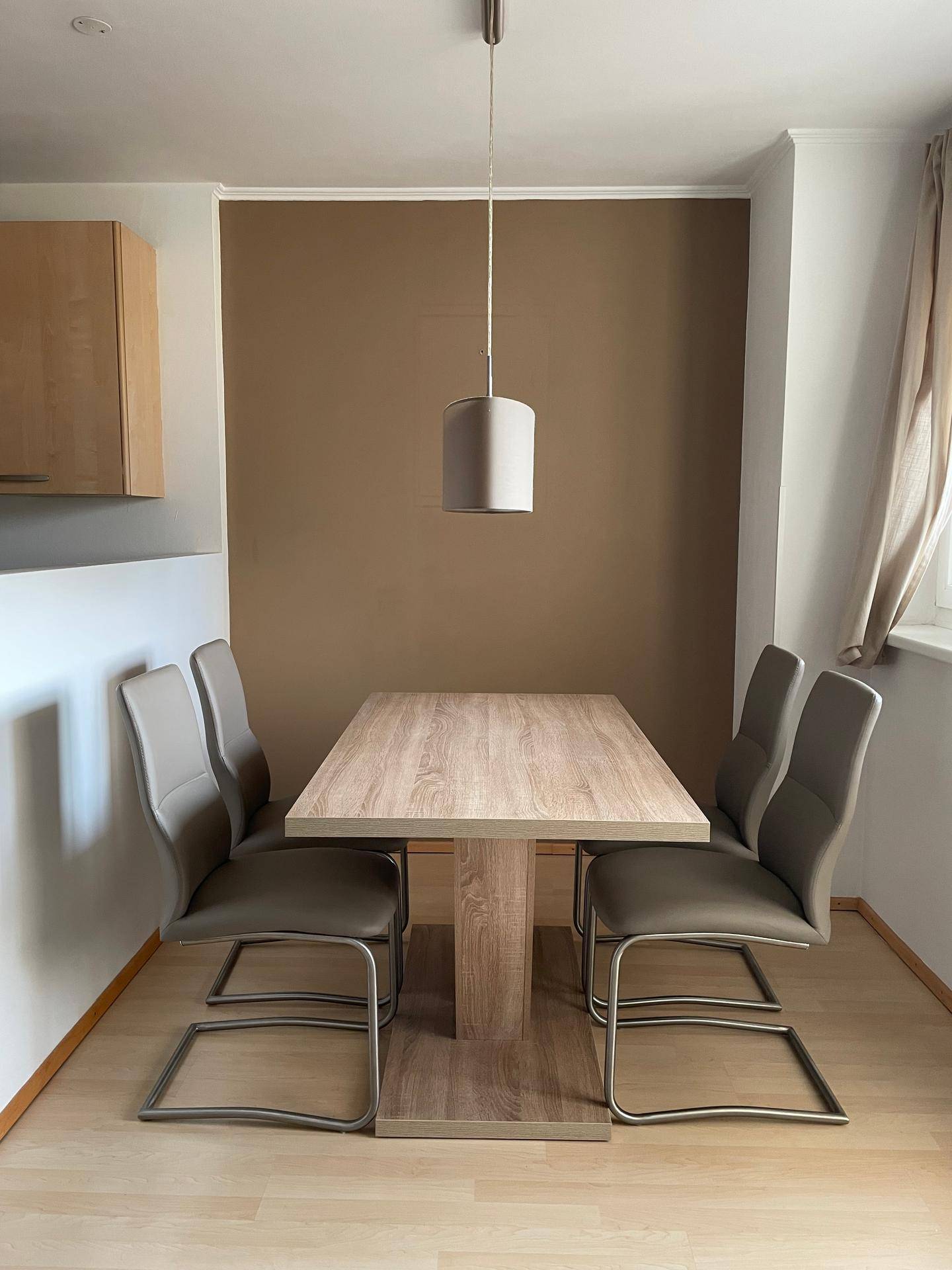 Essbereich mit modernem Holztisch und vier bequemen Stühlen.