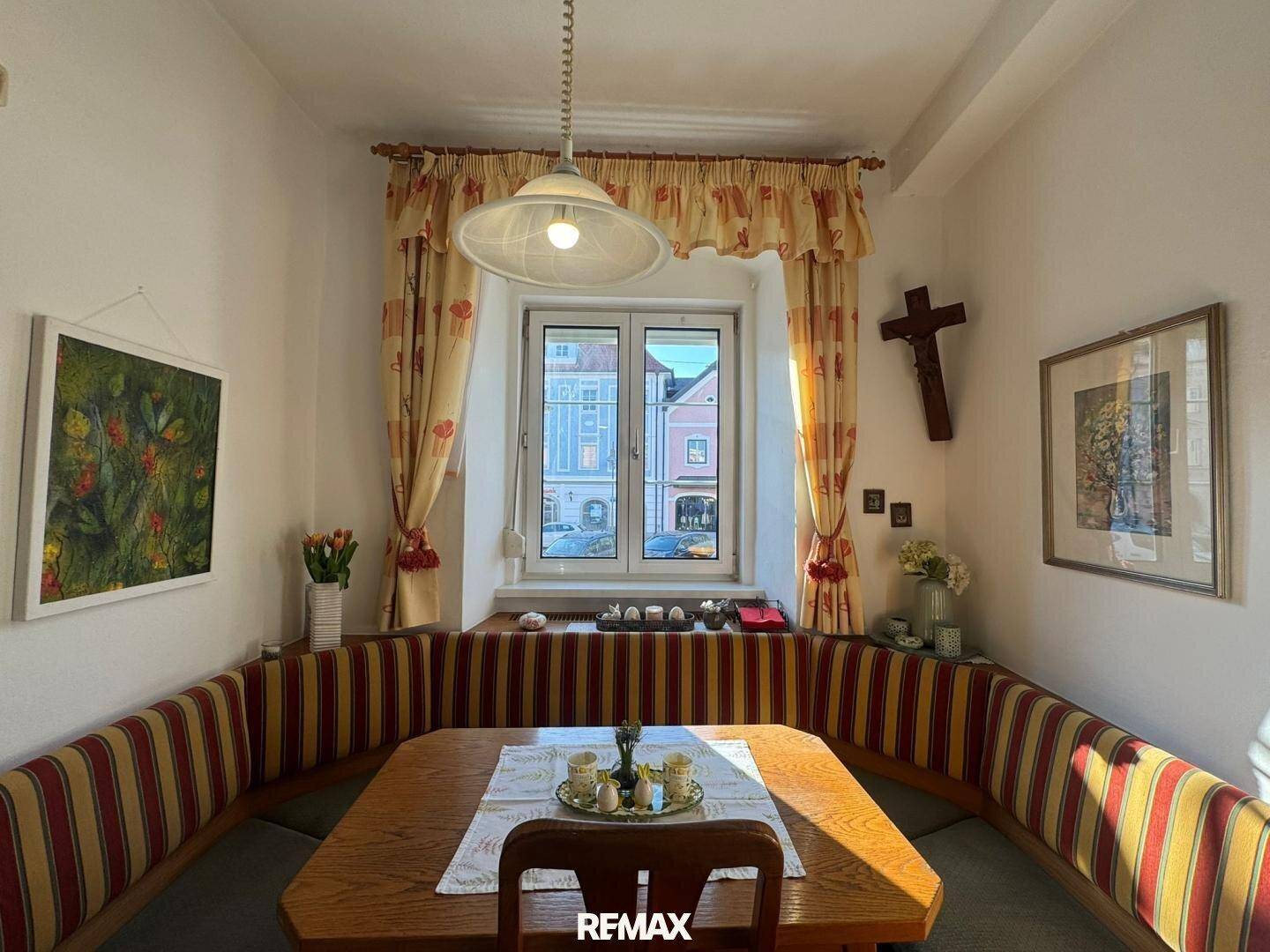Heller Essbereich mit traditioneller Eckbank, Holztisch und Blick auf die gegenüberliegenden Gebäude.