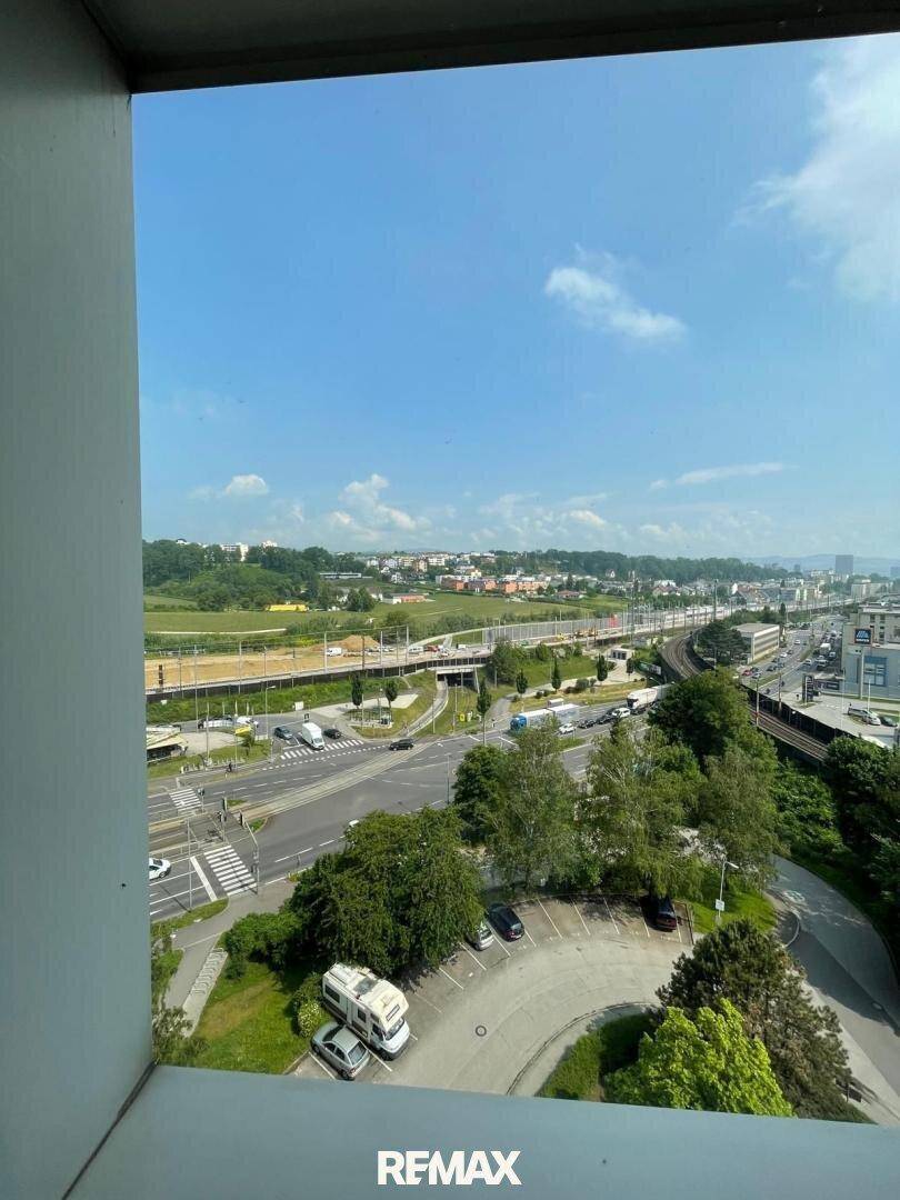 Weitläufiger Blick aus dem Fenster über die Stadt, Straßen und Bahngleise.