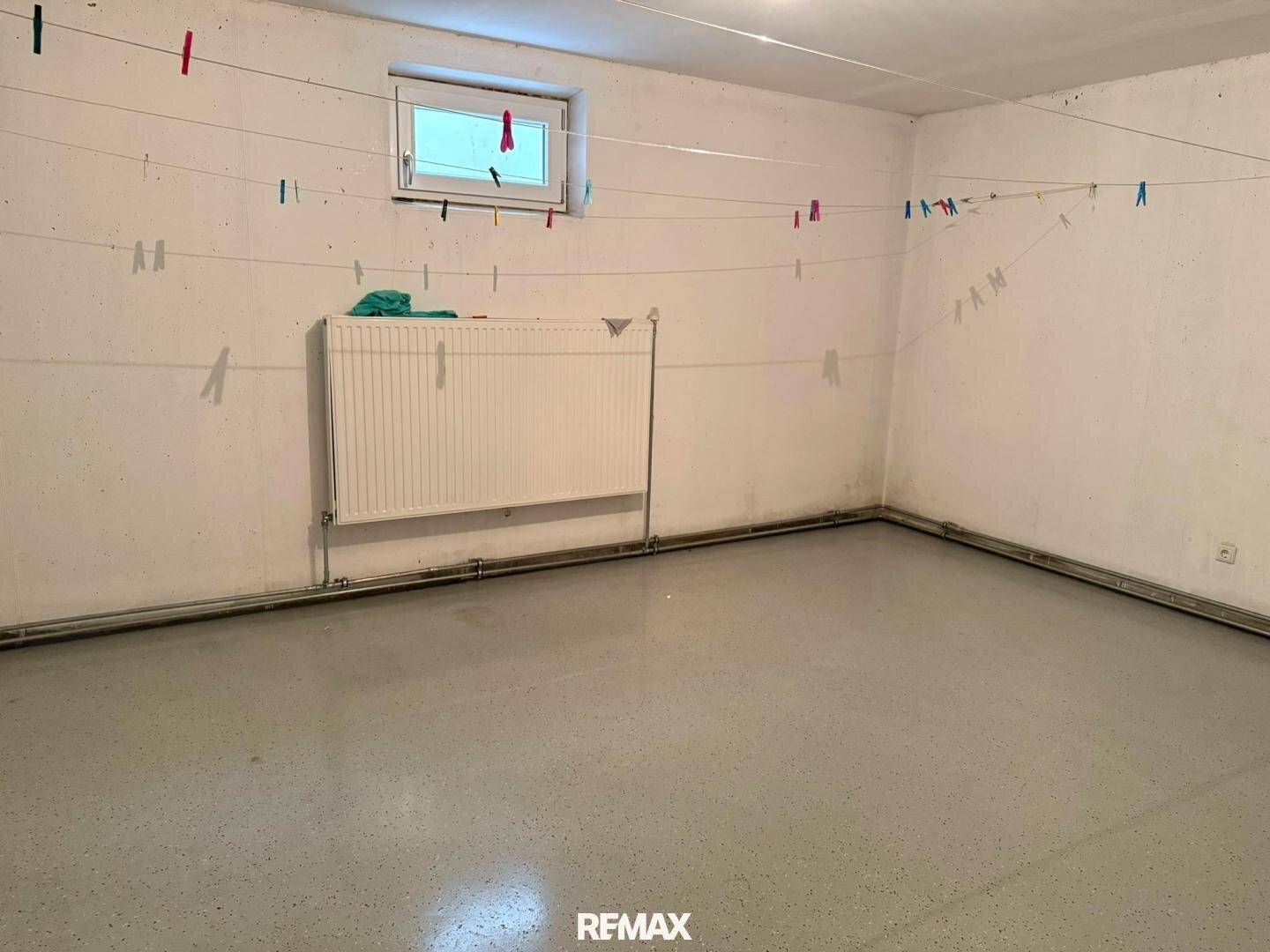Praktischer Hauswirtschaftsraum im Keller mit Wäscheleinen und Heizkörper.