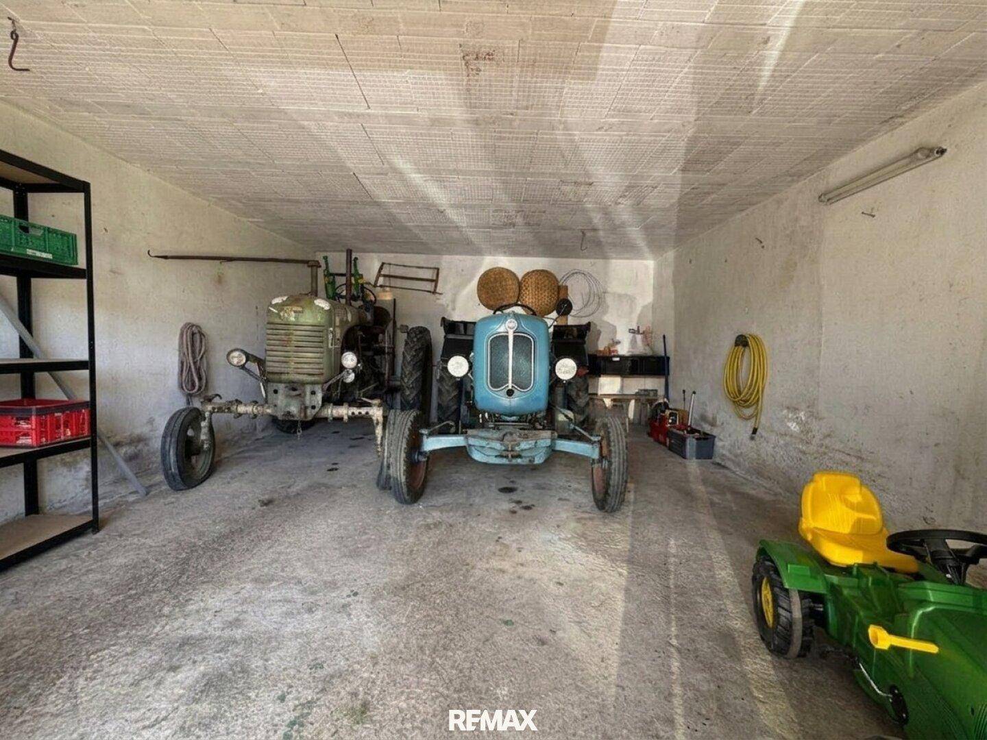 Geräumige Garage mit Betonboden, bietet Platz für Fahrzeuge und Lagerung.