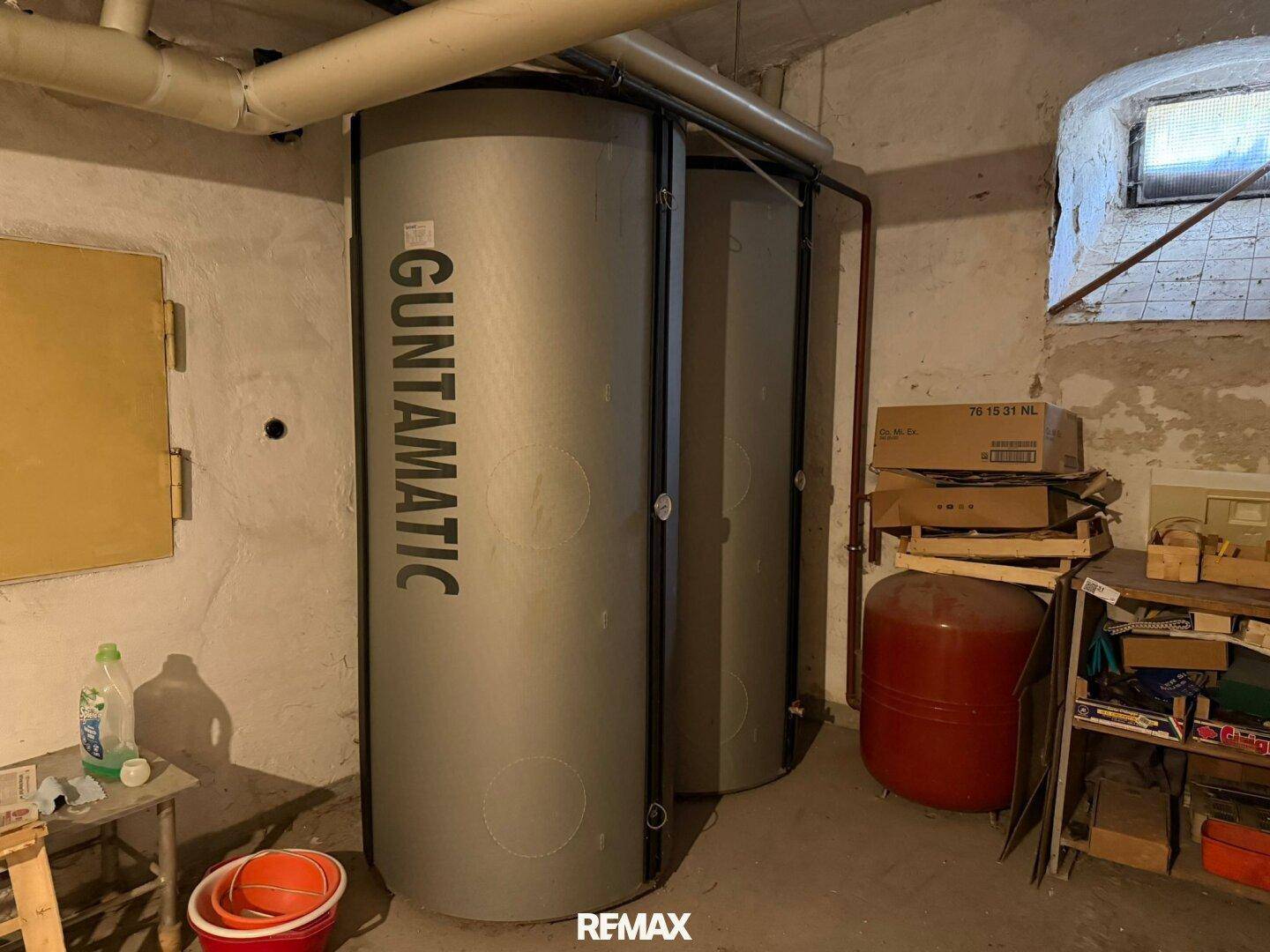 Kellerraum mit großen Warmwasserspeichern und einem kleinen Fenster für Belüftung.