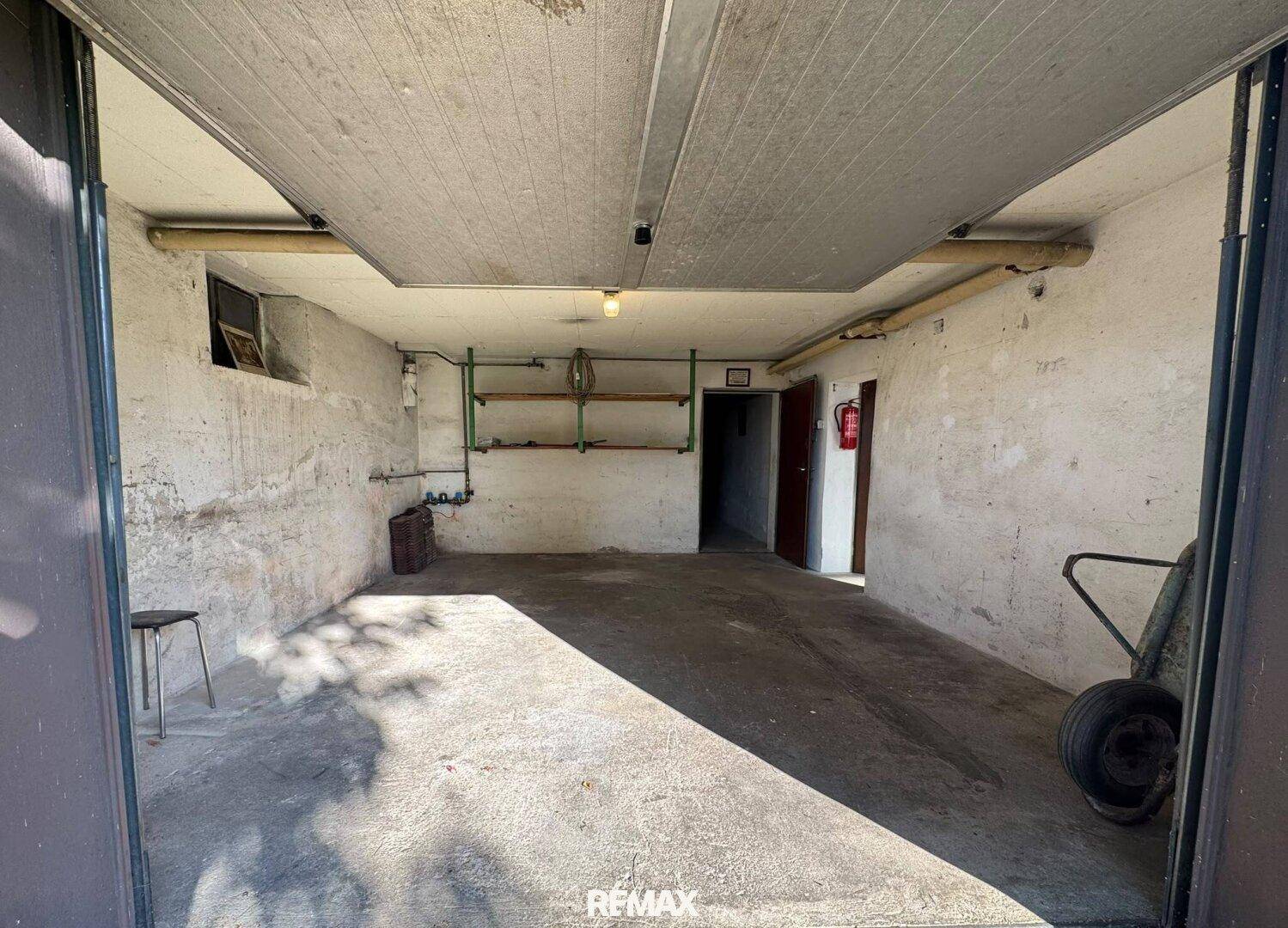 Geräumige Garage mit Betonboden und Stauraum, bereit für Fahrzeuge oder Lagerung.
