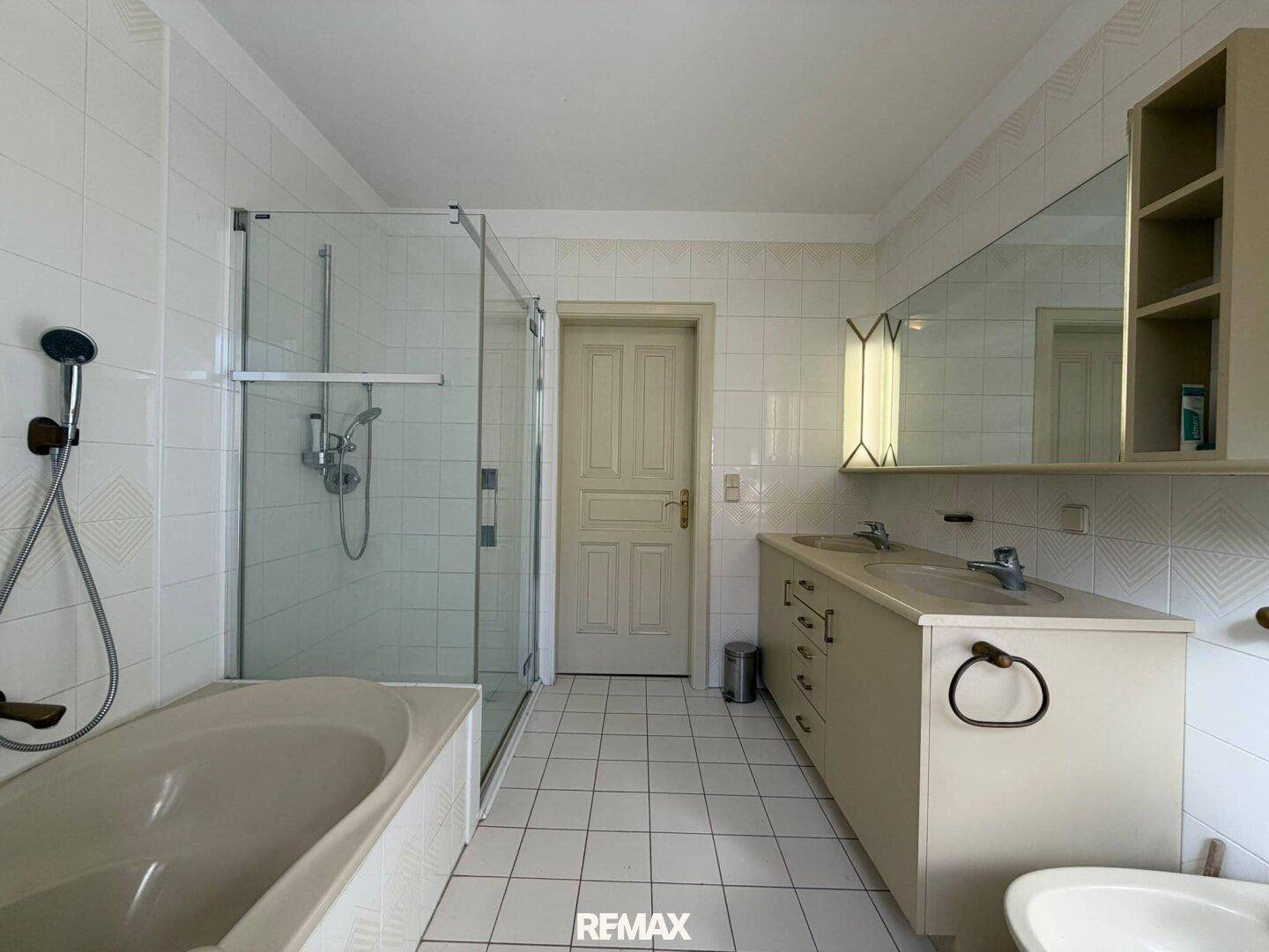 Geräumiges Badezimmer mit Doppelwaschbecken, Badewanne und separater Duschkabine.