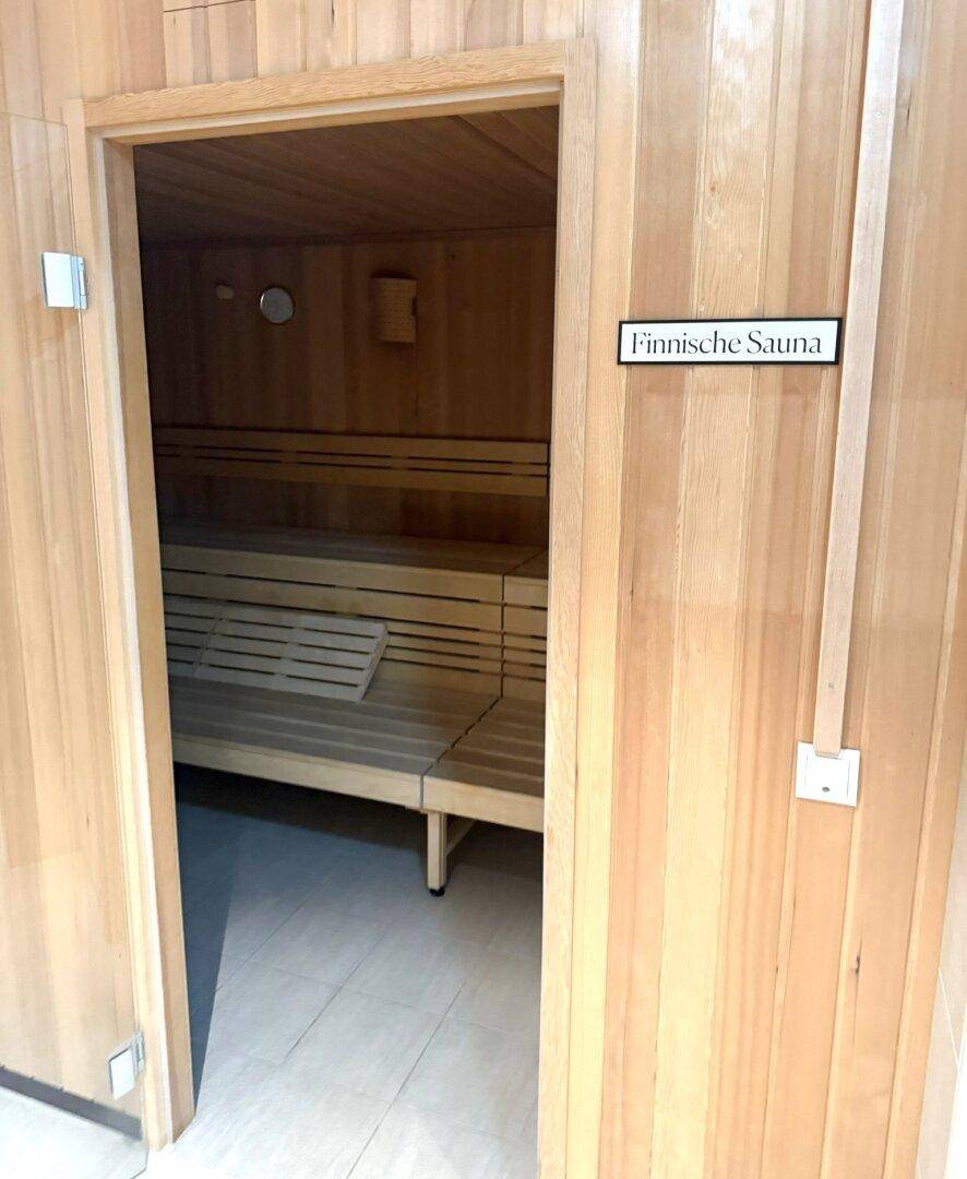Traditionelle finnische Sauna mit Holzverkleidung und mehrstufigen Bänken, für klassische Saunagänge.