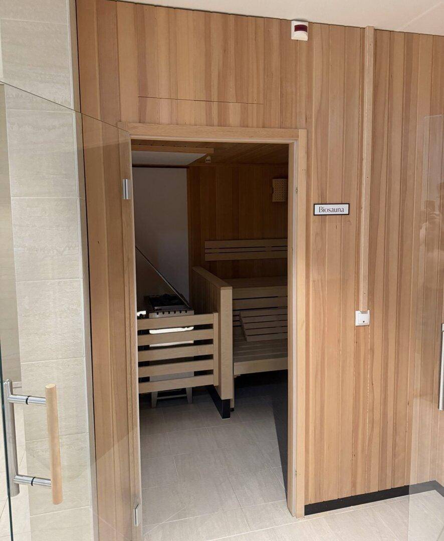 Holzverkleidete Bio-Sauna mit Bänken und Heizofen, bietet Entspannung und Wohlbefinden.