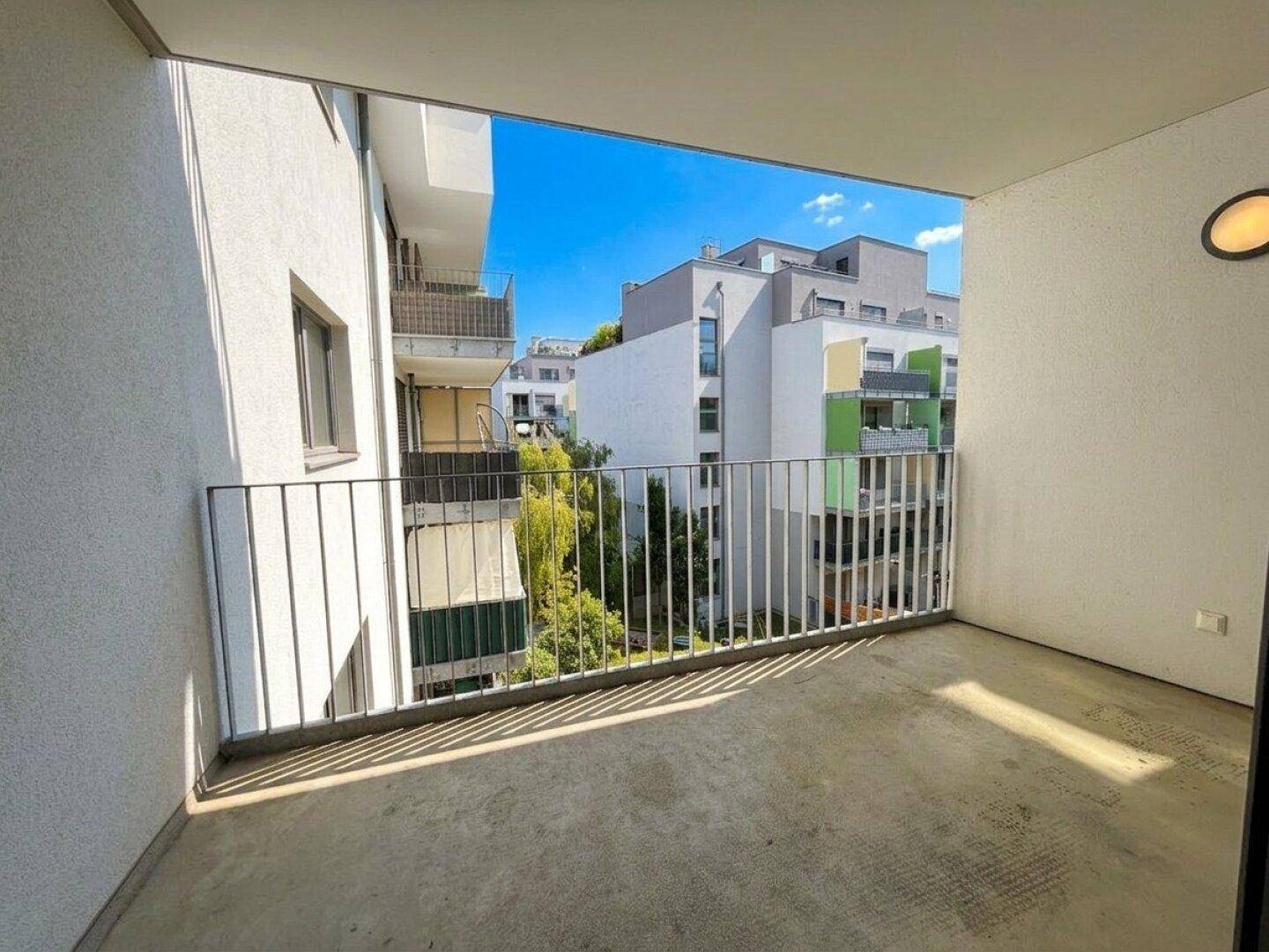 Geräumiger Balkon mit Blick auf die umliegenden Wohngebäude und viel Grün.