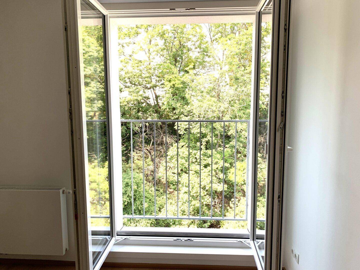 Französischer Balkon mit Blick ins Grüne, der viel Licht in den Raum lässt.