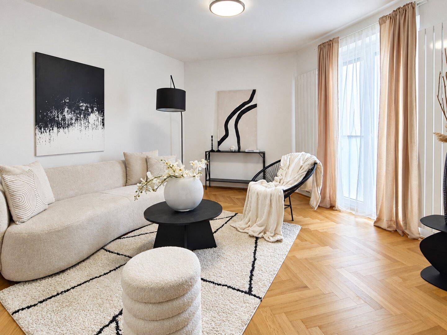 Gemütliches Wohnzimmer mit beigem Sofa, schwarzem Couchtisch und stilvoller Dekoration.