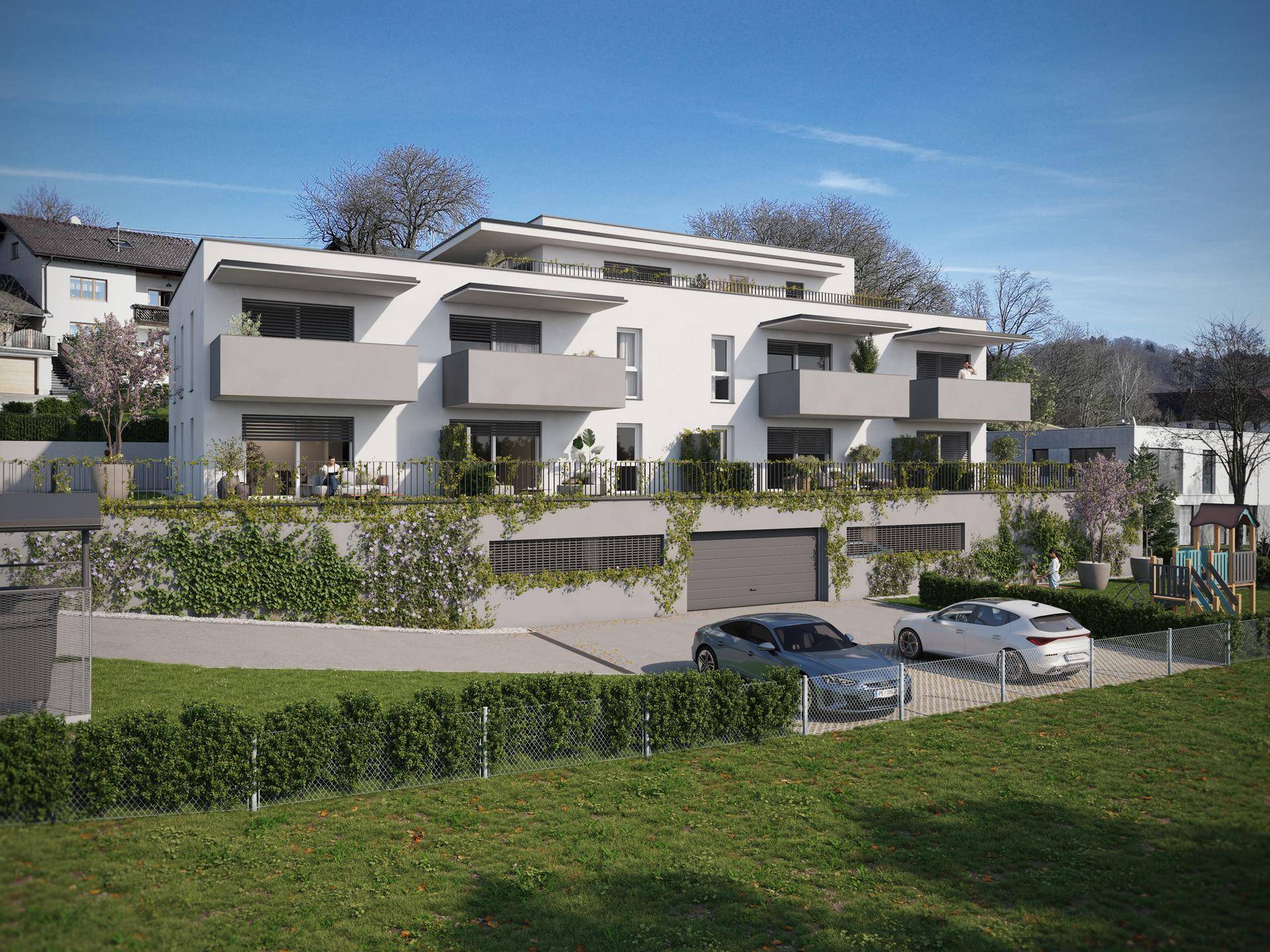 Moderne Wohnanlage mit weißer Fassade, Balkonen und Zufahrt mit Parkplätzen.