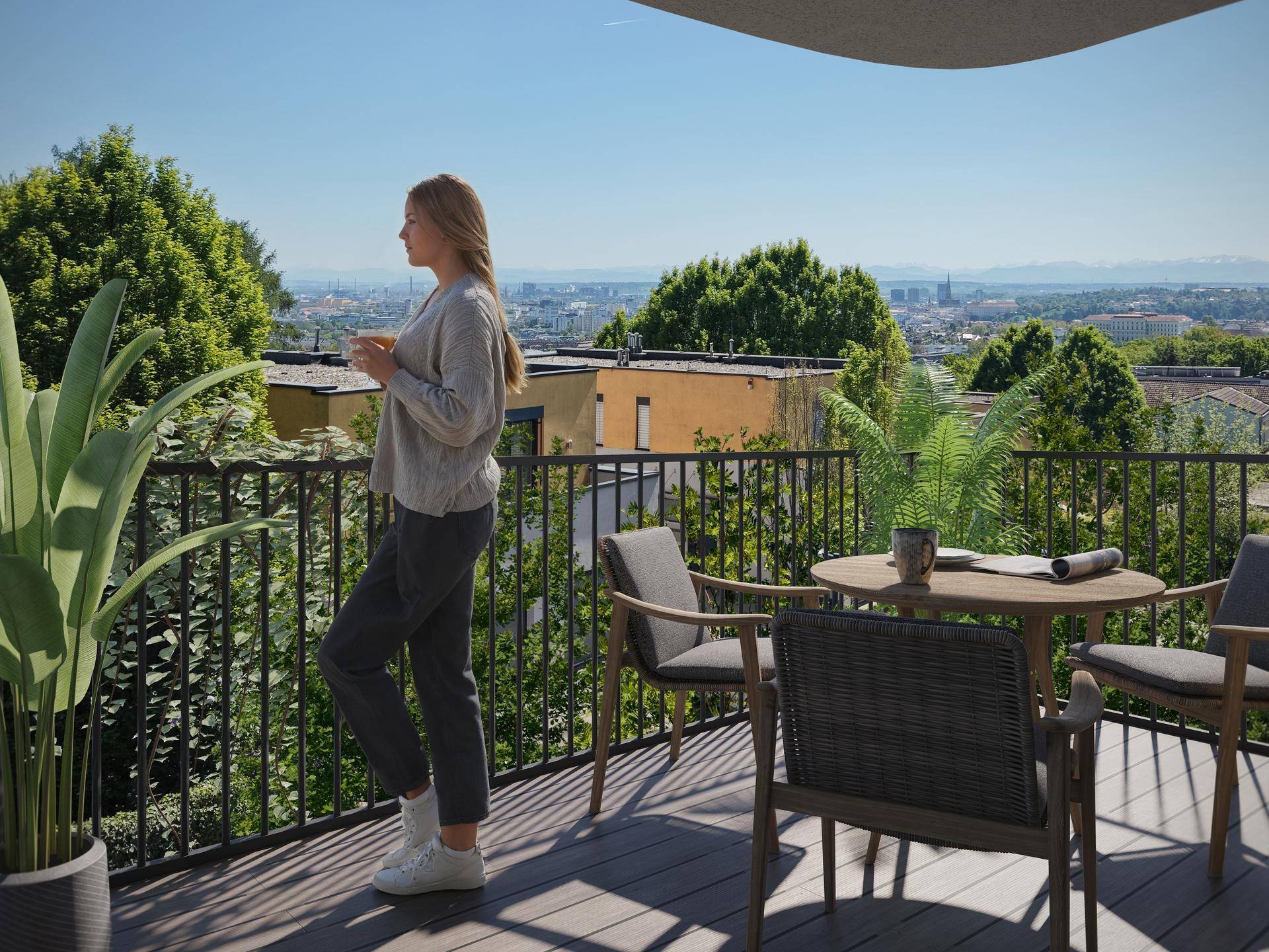 Geräumiger Balkon mit Holzboden, Sitzgelegenheiten und einem weiten Blick über die Stadt.