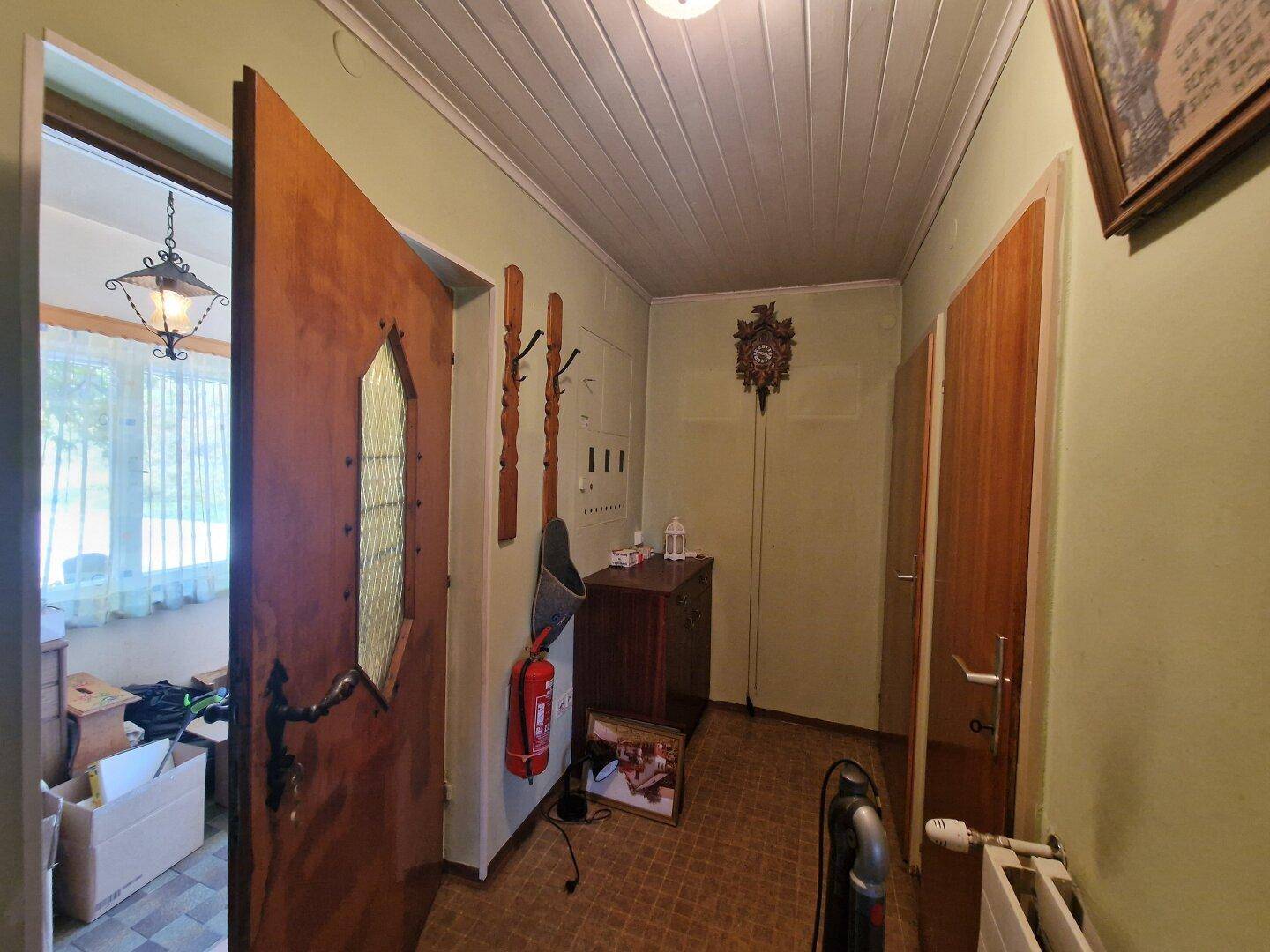 Eingangsbereich mit Holztür, Garderobe und traditioneller Dekoration.