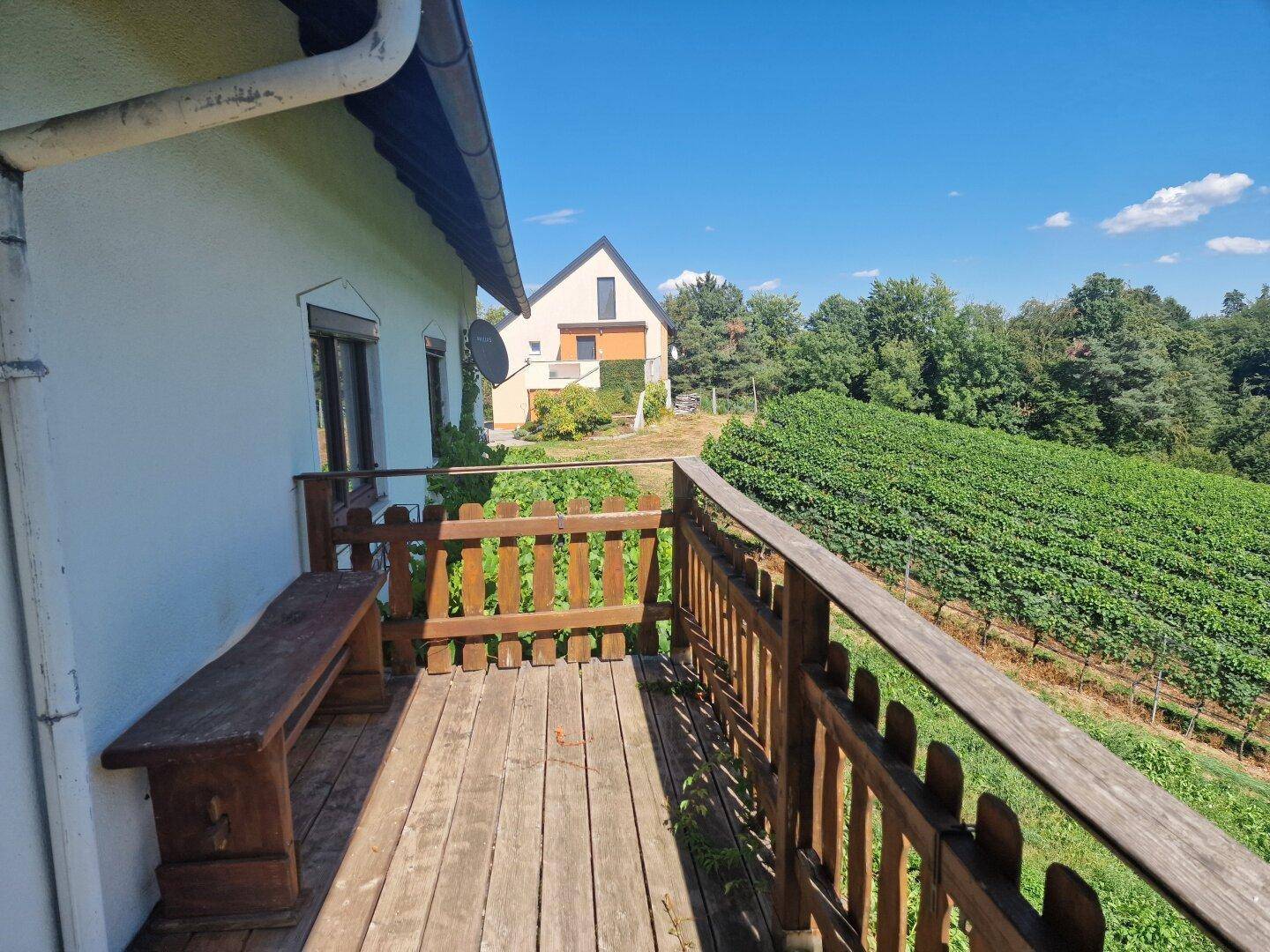 Balkon mit Holzboden und Geländer, bietet einen weiten Blick auf die umliegenden Weinberge.