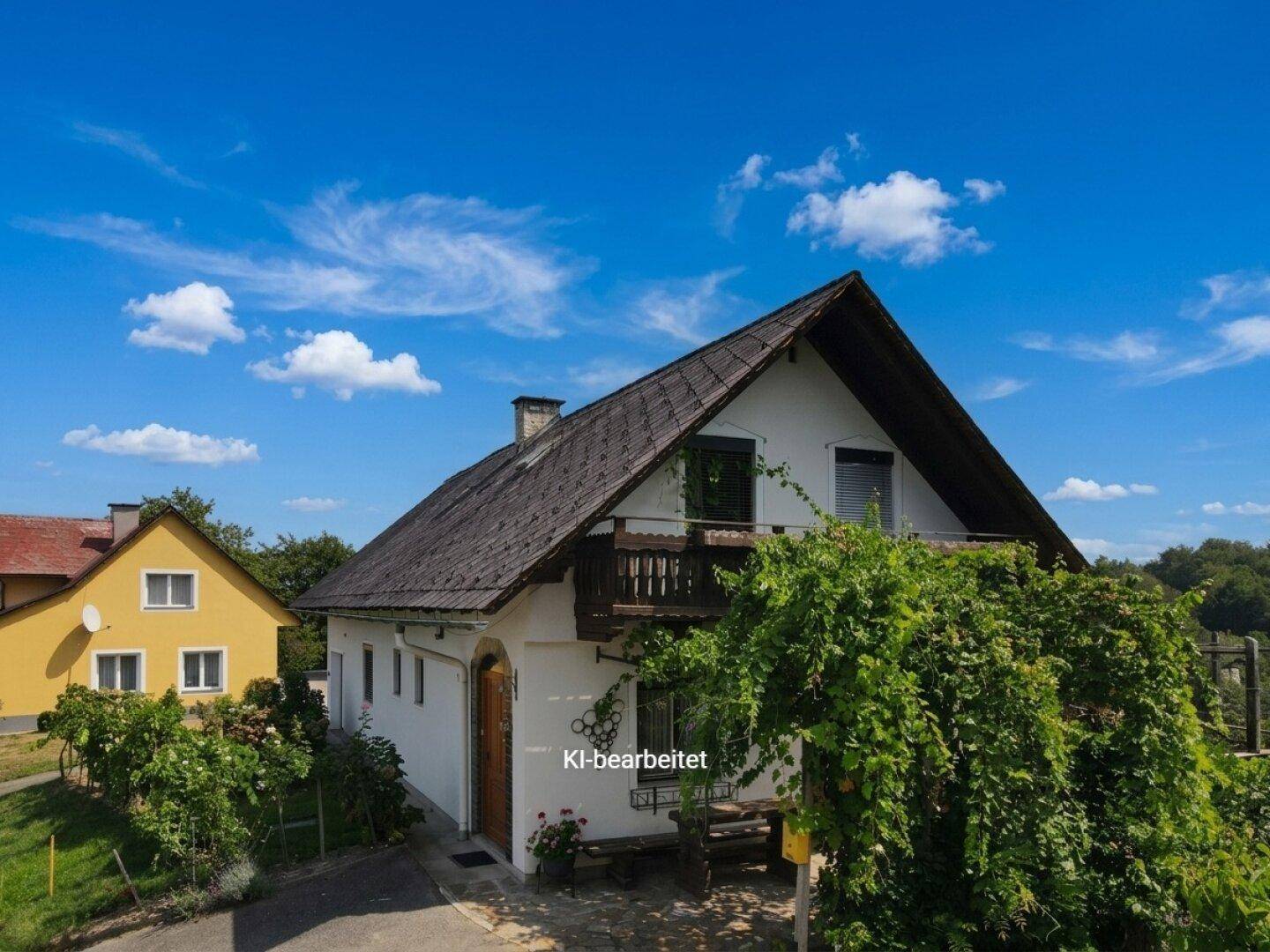 Luftaufnahme des Haupthauses mit Satteldach und einem gelben Nachbargebäude.