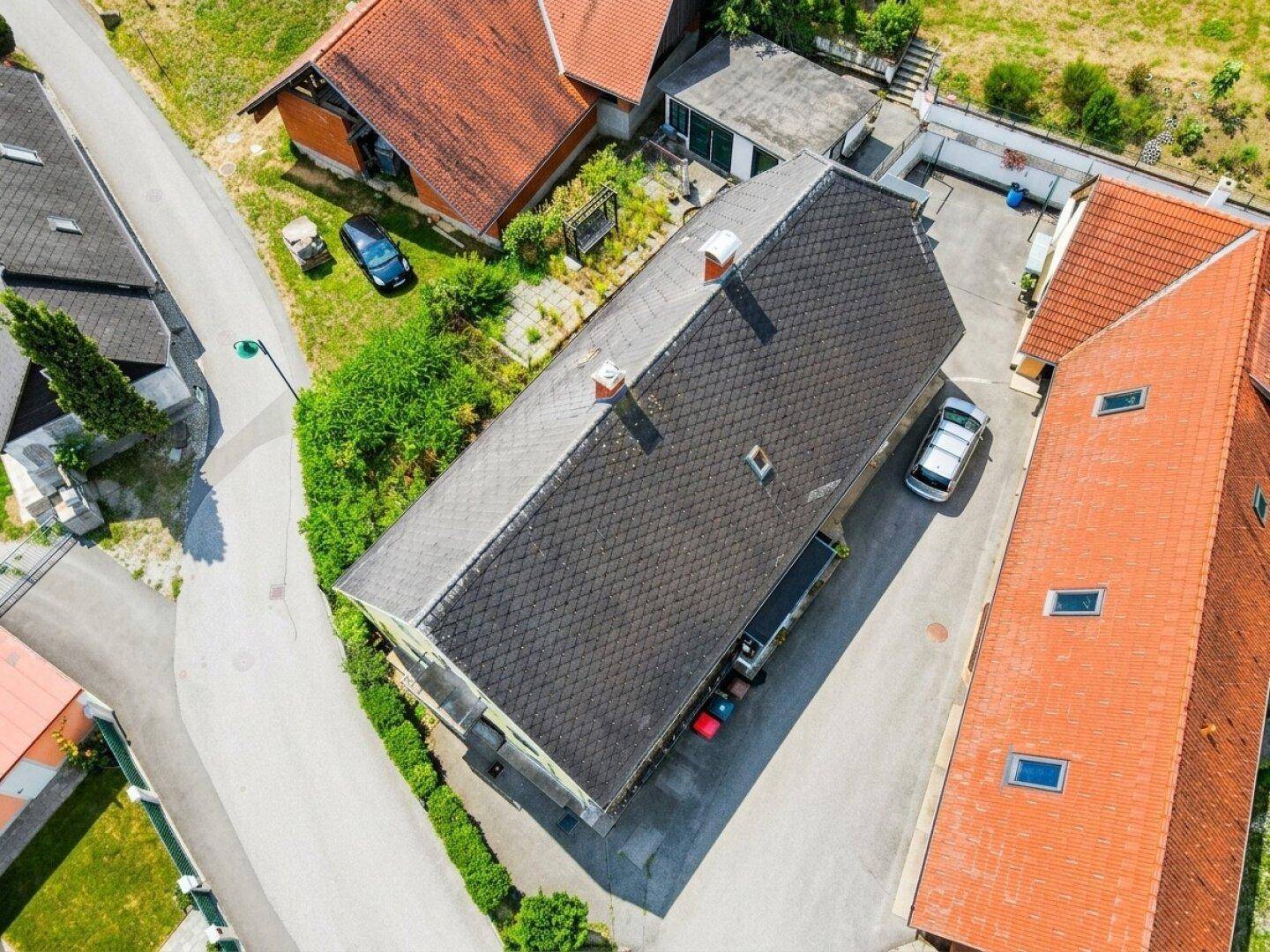 Luftaufnahme des Anwesens mit Wohnhaus, Nebengebäuden und umliegender Natur.