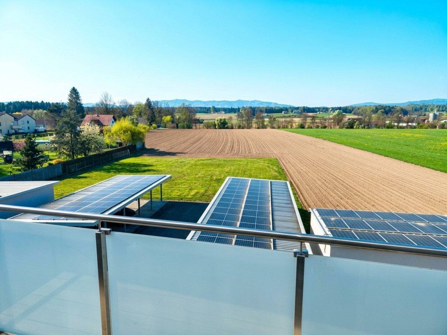 Weitläufiger Blick vom Balkon über Felder, Wiesen und die umliegende Landschaft.